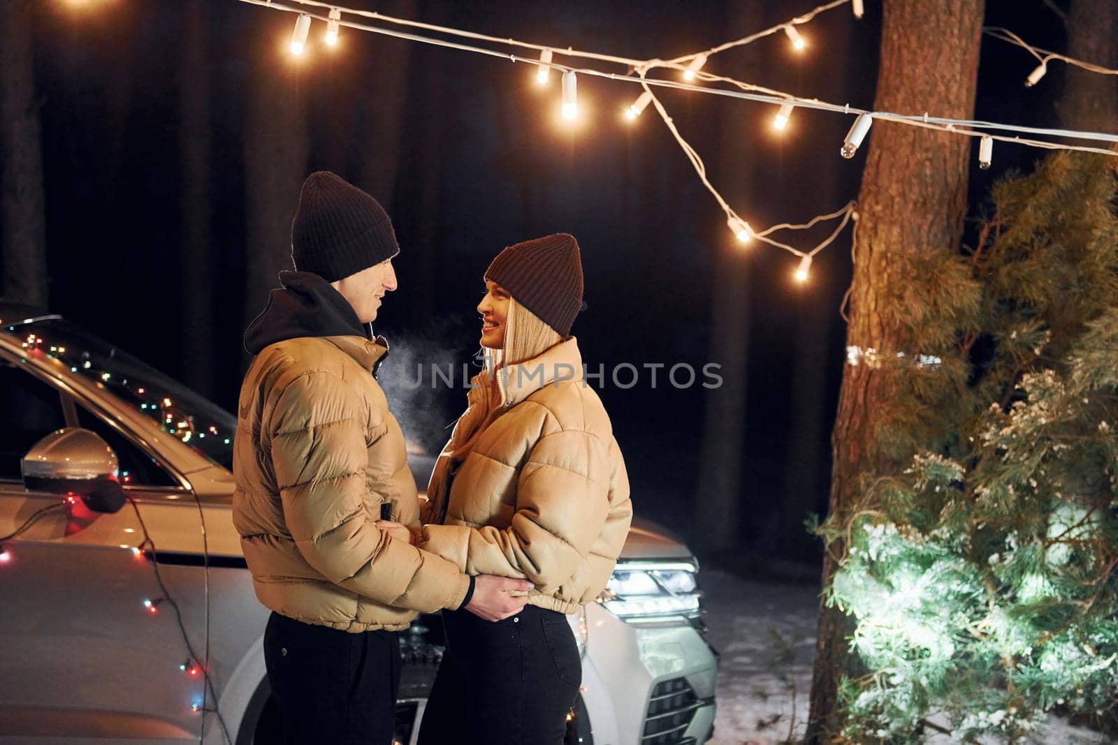 Conception of love. Couple standing in the forest and celebrating New year.