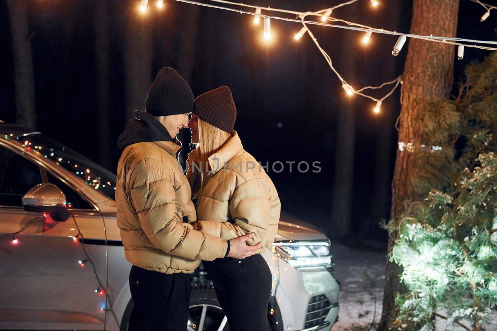 Looking at each other. Couple standing in the forest and celebrating New year.
