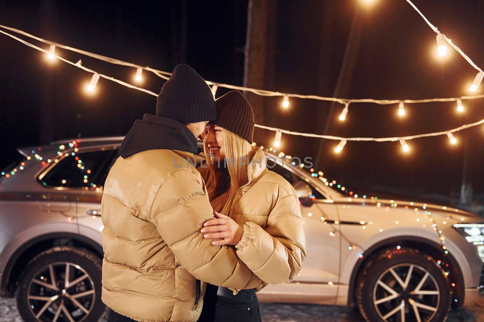 Holiday mood and decorations. Couple standing in the forest and celebrating New year.
