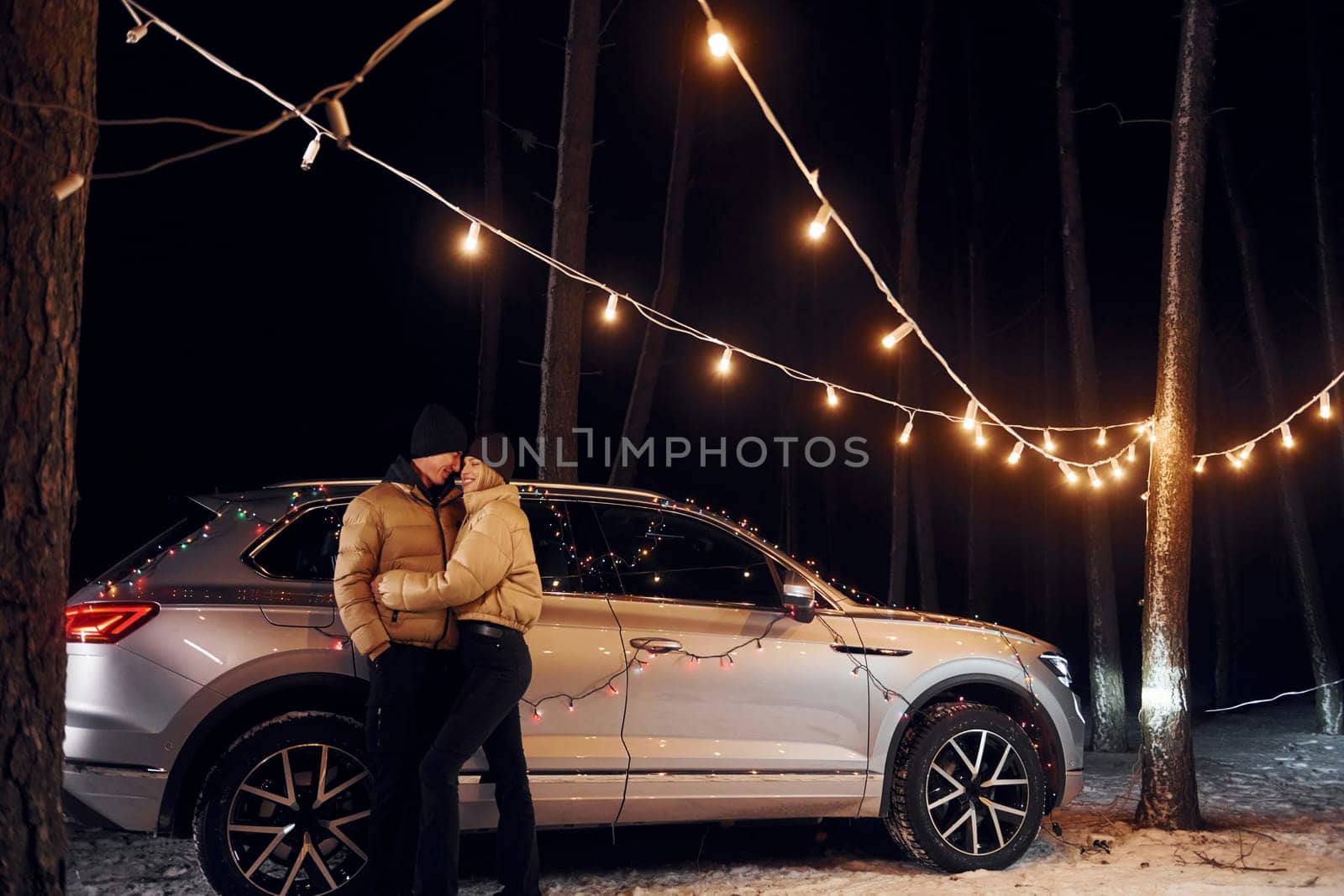 Love and hugs. Couple standing in the forest and celebrating New year.