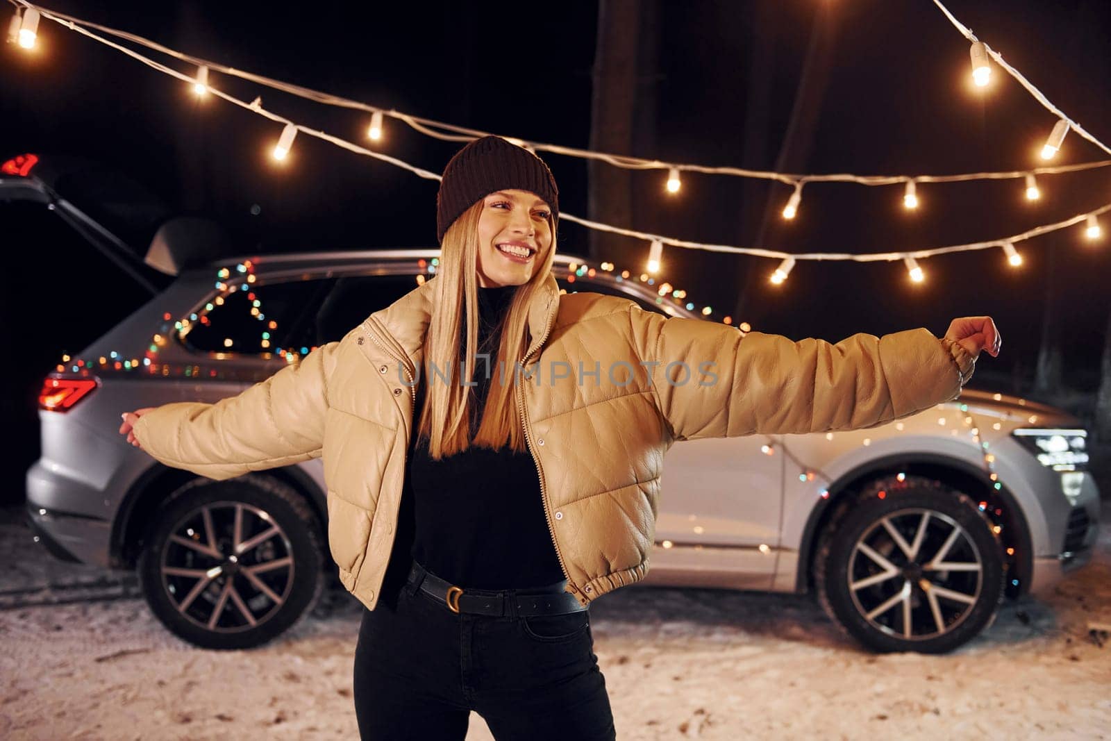 Car behind. Woman standing in the forest and celebrating New year.
