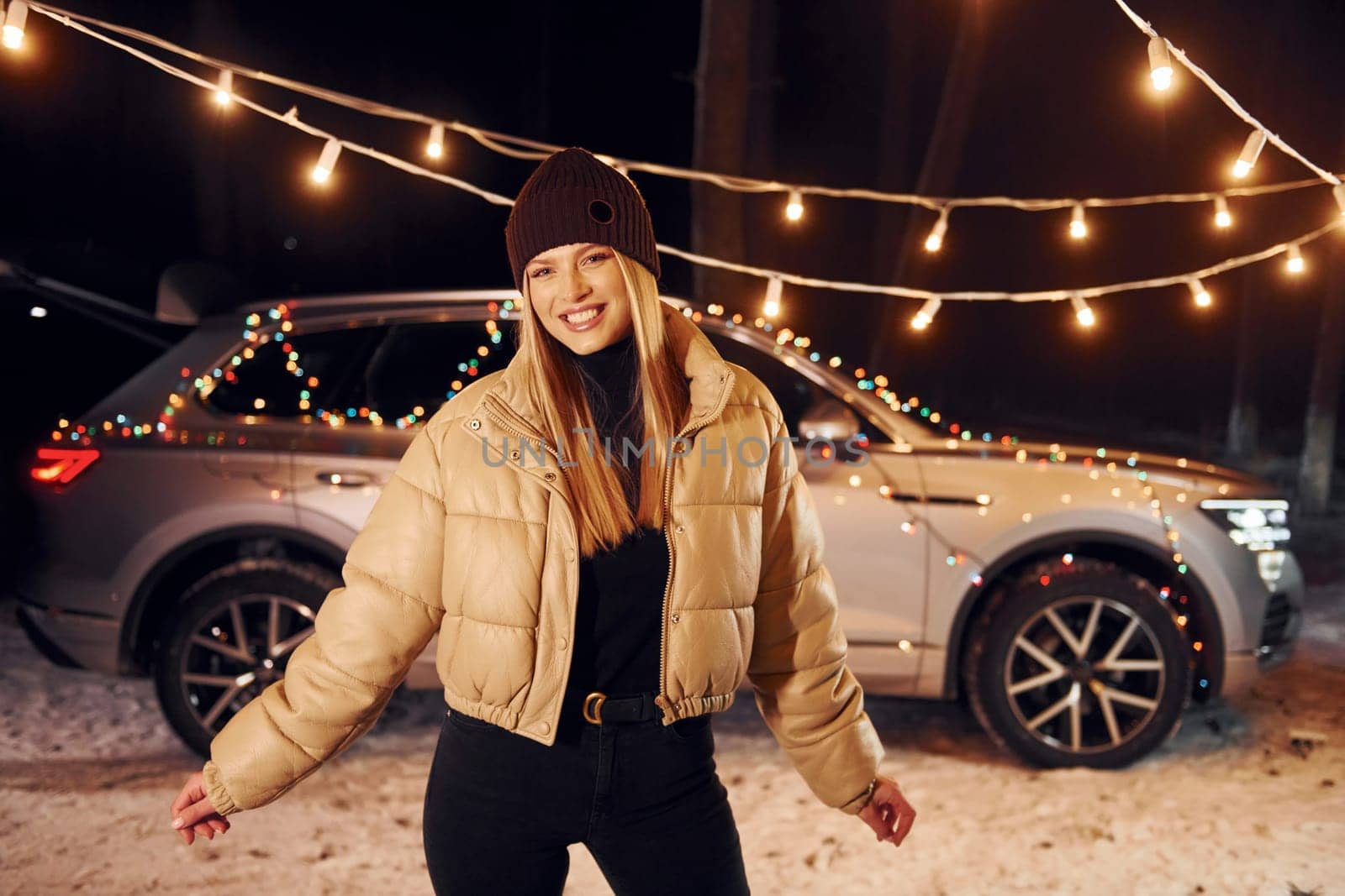 Car behind. Woman standing in the forest and celebrating New year.