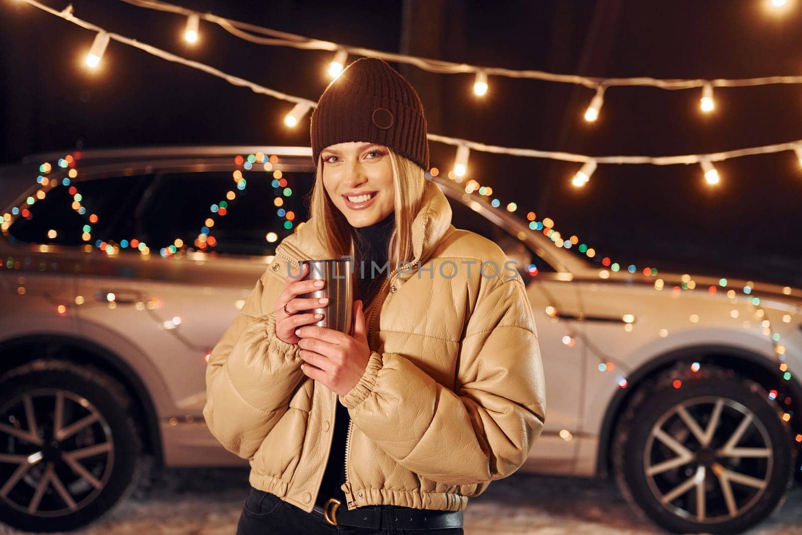 With thermos. Woman standing in the forest and celebrating New year.