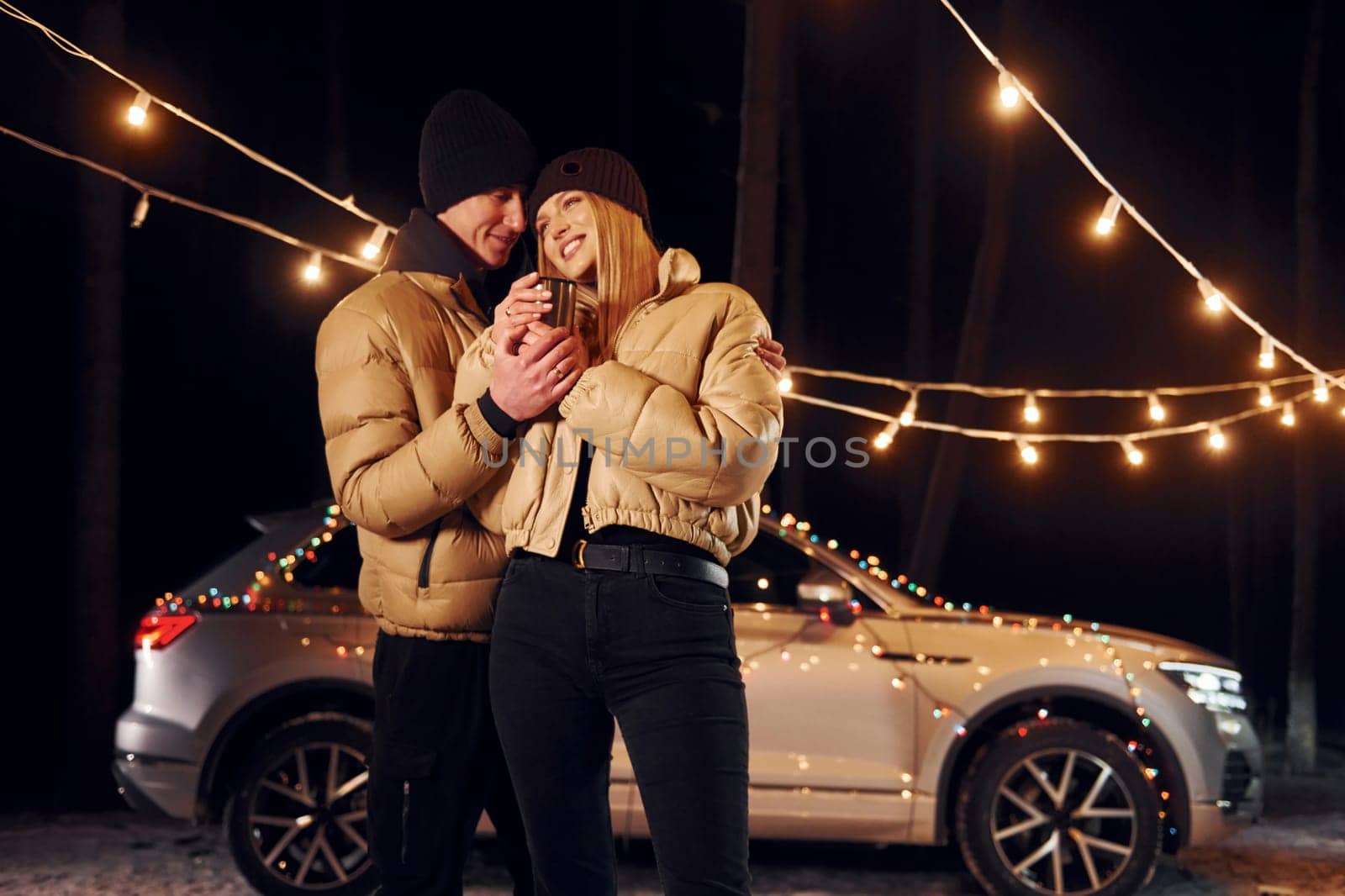 Love and hugs. Couple standing in the forest and celebrating New year.