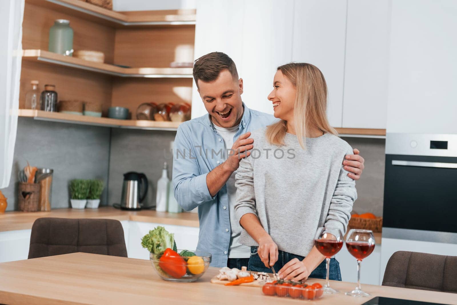 Cute people. Couple preparing food at home on the modern kitchen.