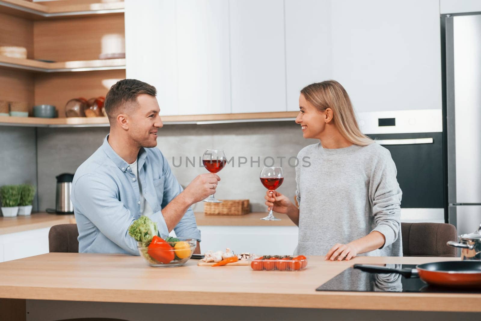 Cute people. Couple preparing food at home on the modern kitchen.