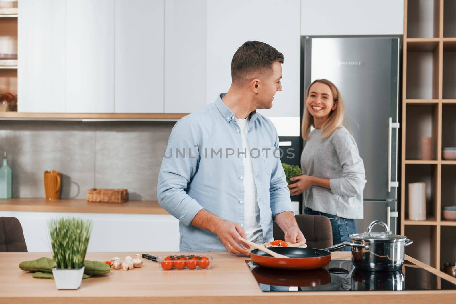 Preparing dinner. Couple at home on the modern kitchen by Standret