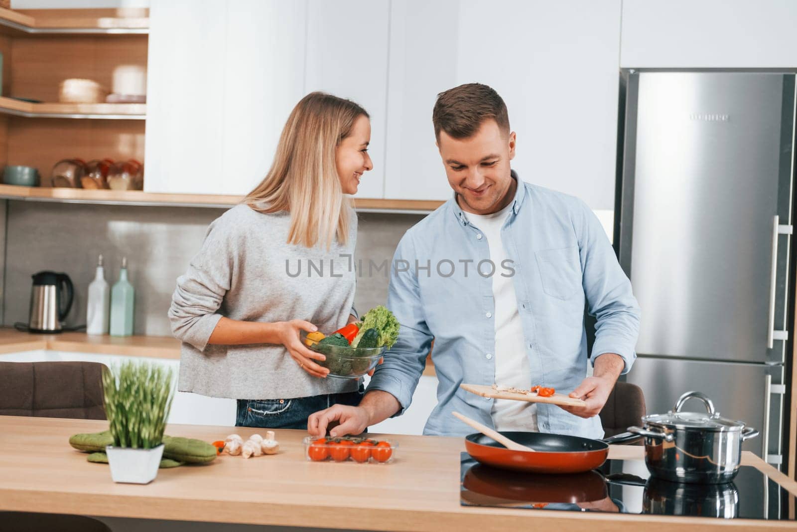 Preparing dinner. Couple at home on the modern kitchen by Standret