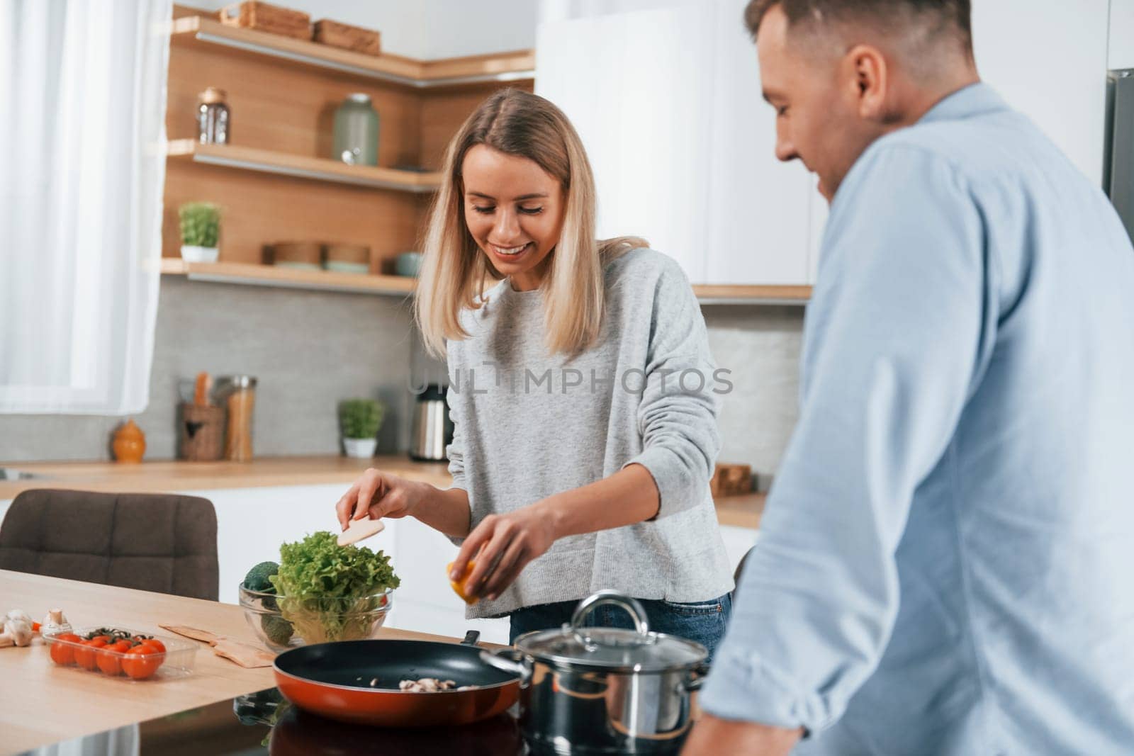 Delicious dinner. Couple preparing food at home on the modern kitchen.