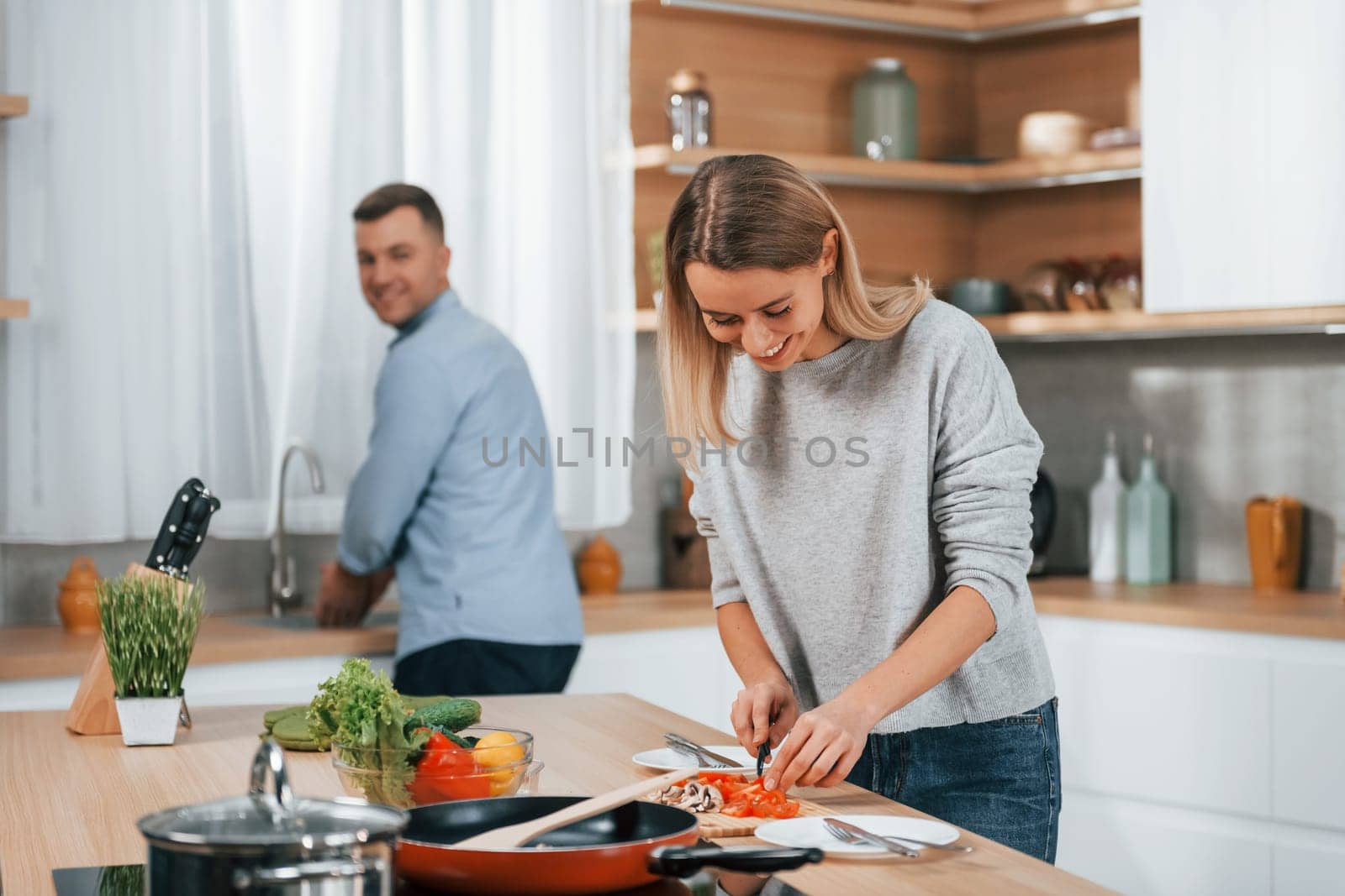 Positive emotions. Couple preparing food at home on the modern kitchen.