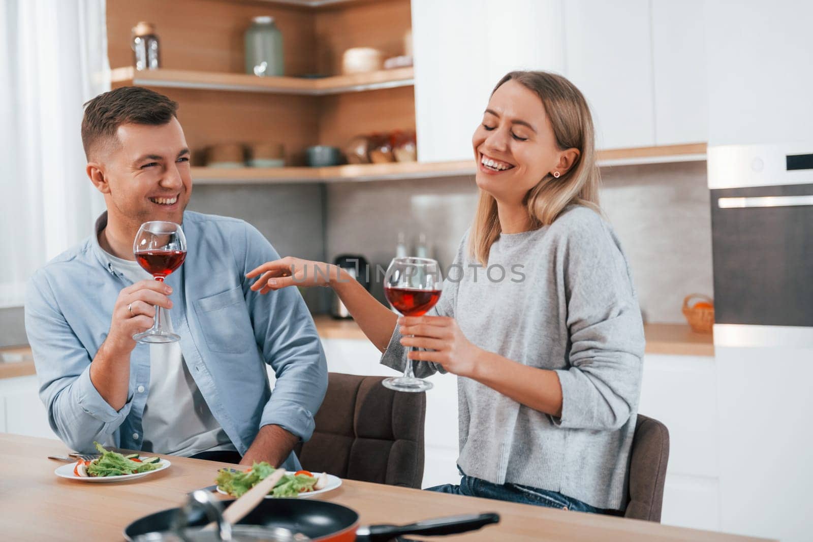 Tasting delicious food. Couple at home on the modern kitchen.
