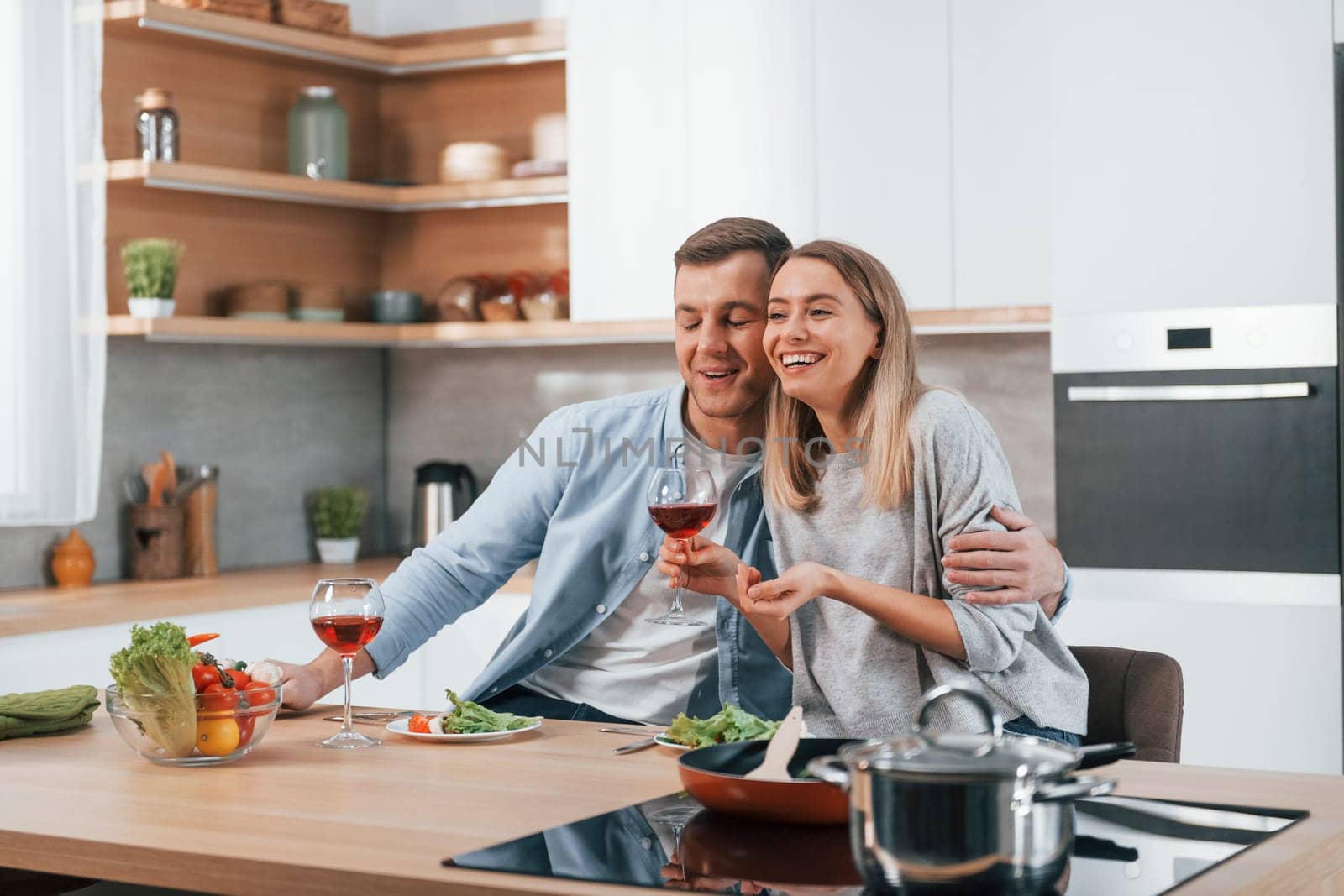 Having weekend together. Couple preparing food at home on the modern kitchen.