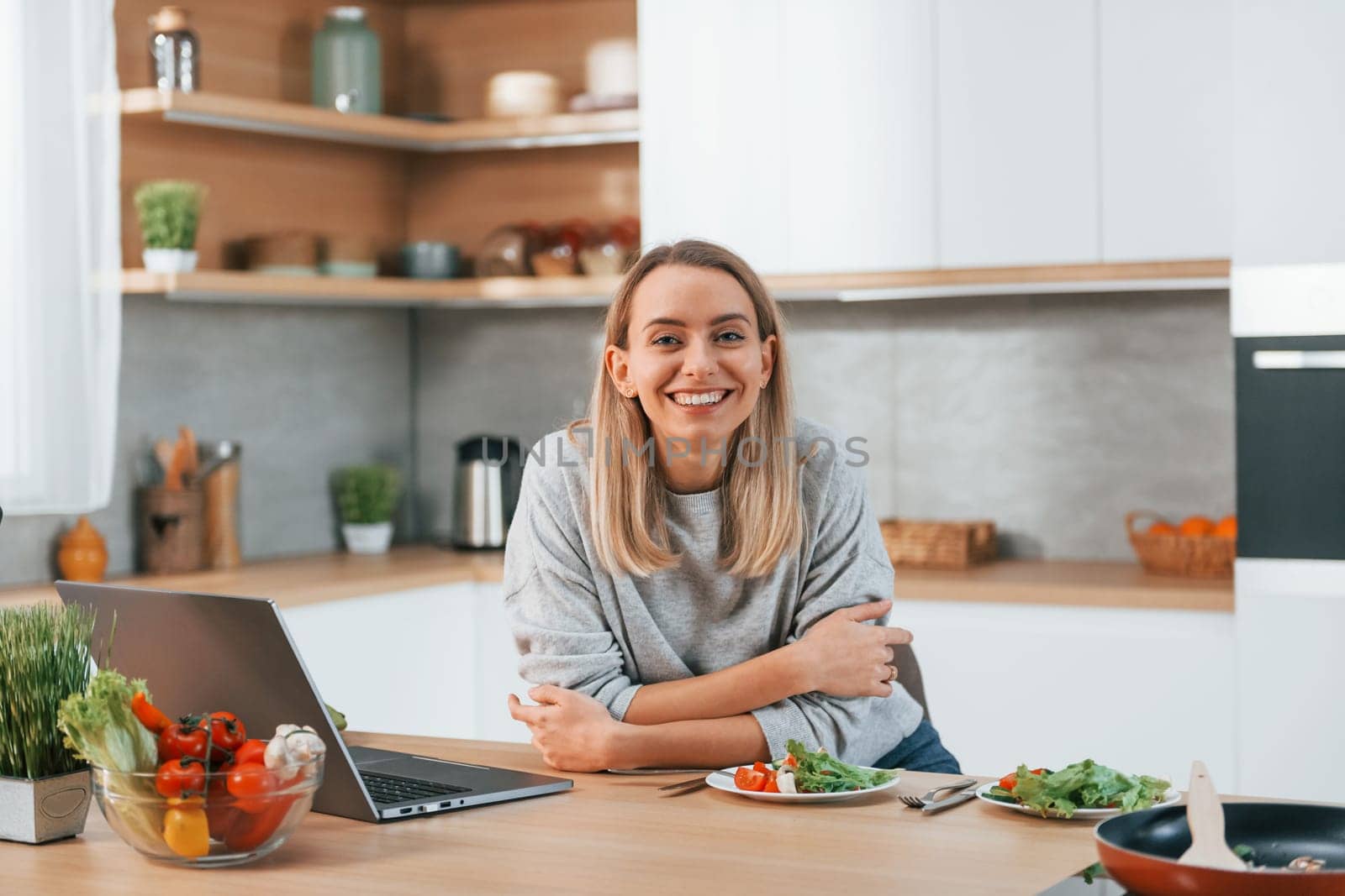 Woman preparing food at home on the modern kitchen by Standret