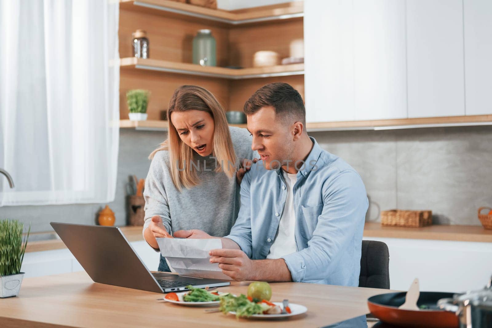 Having fun. Couple preparing food at home on the modern kitchen.