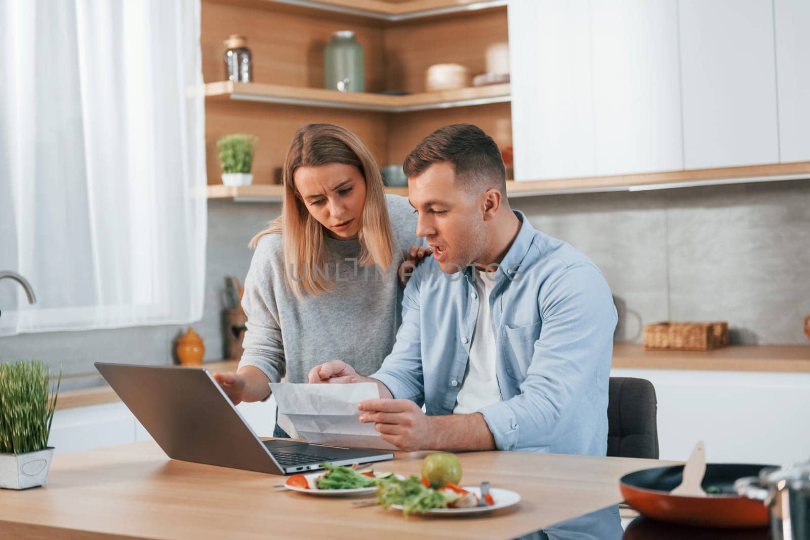 Having fun. Couple preparing food at home on the modern kitchen.