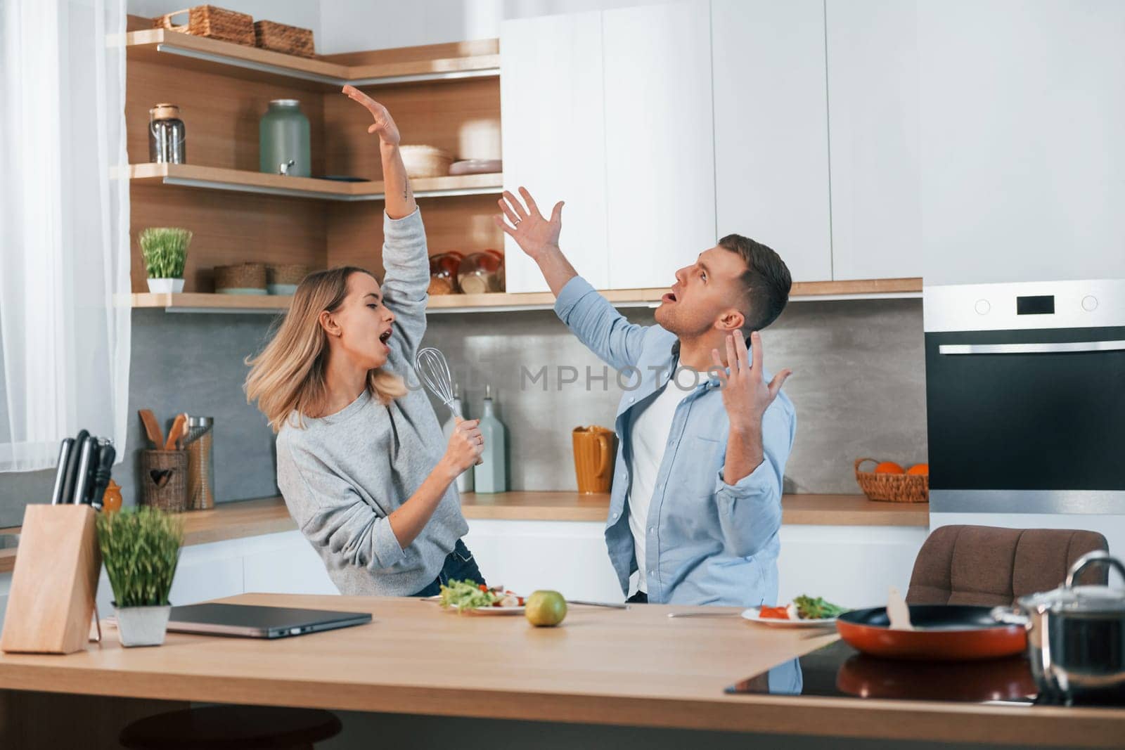 Having fun. Couple preparing food at home on the modern kitchen.