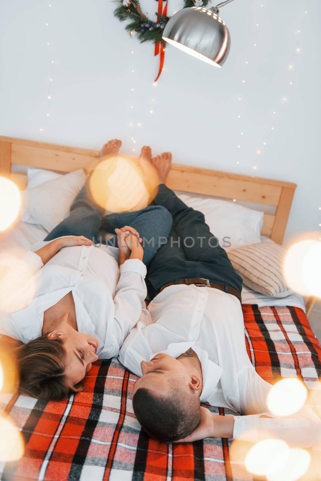 Looking at each other. Lovely couple celebrating holidays together indoors.