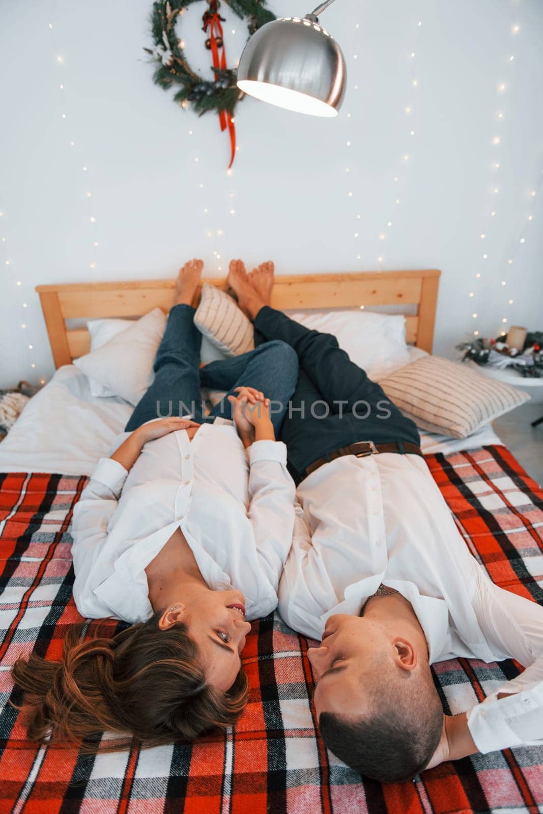 Looking at each other. Lovely couple celebrating holidays together indoors.