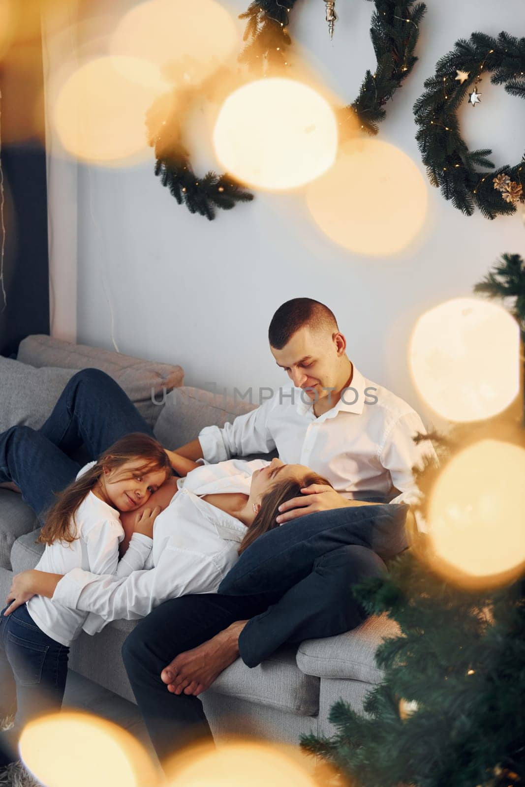 Laying down on the bed. Happy family celebrating holidays indoors together.