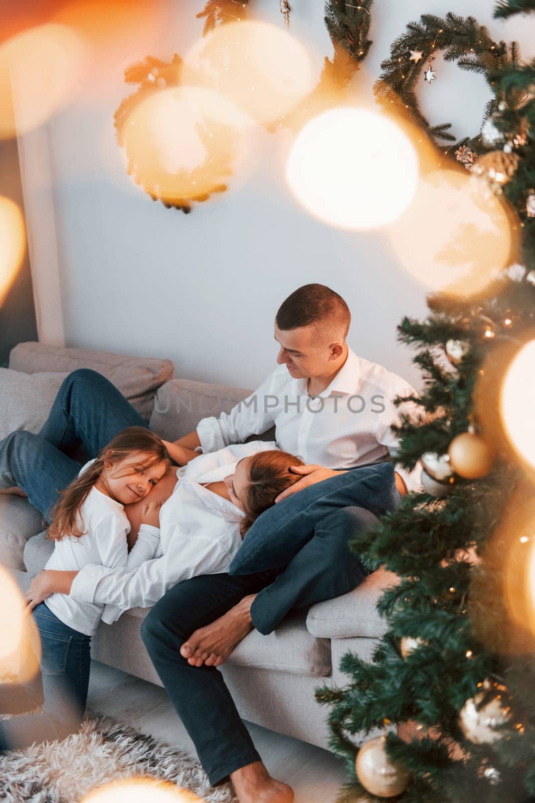 Laying down on the bed. Happy family celebrating holidays indoors together.