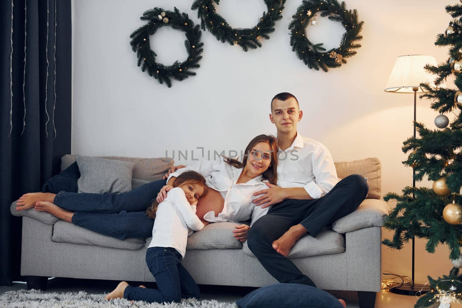 With Christmas tree. Happy family celebrating holidays indoors together.