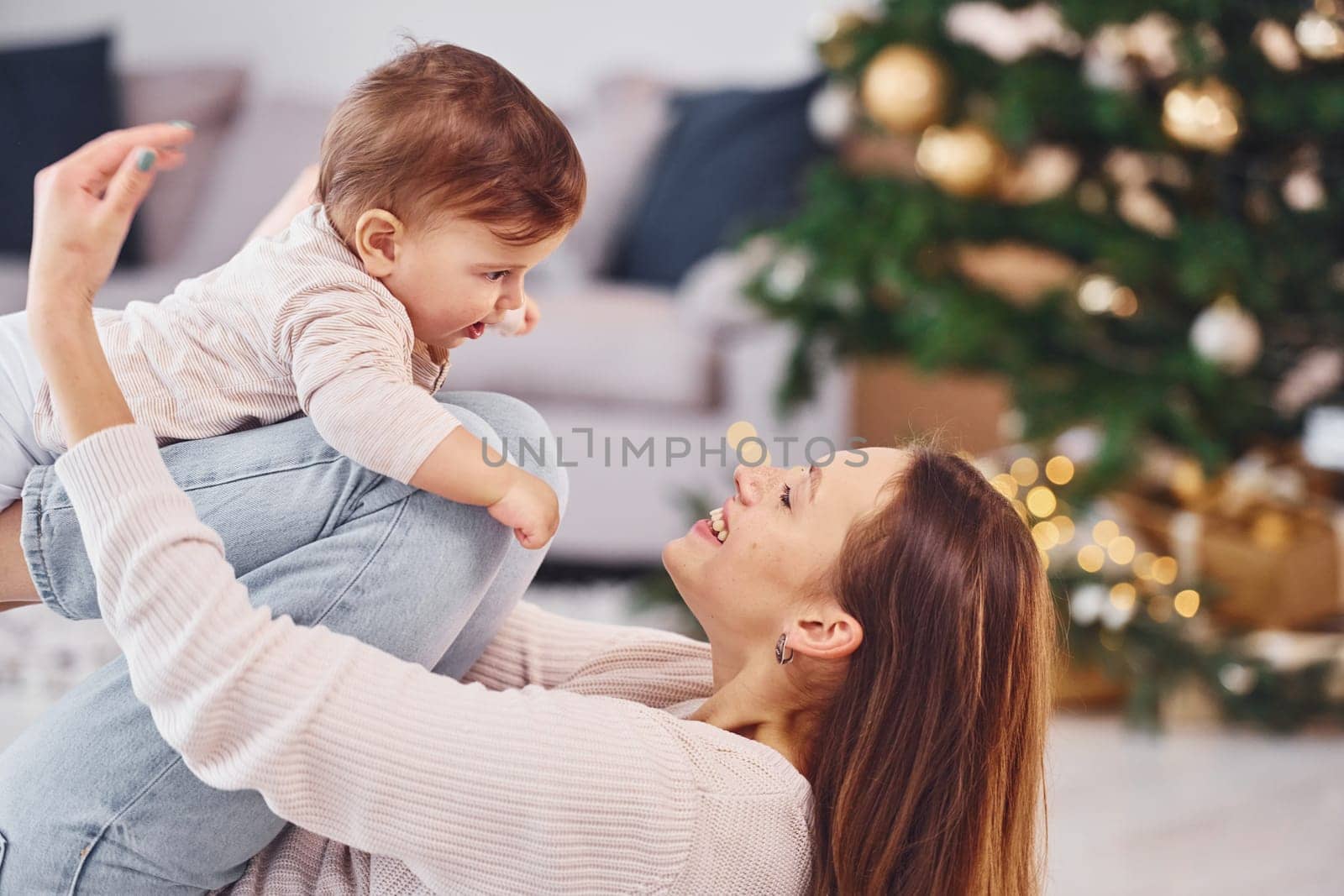 Having fun. Mother with her little daughter is indoors at home together.