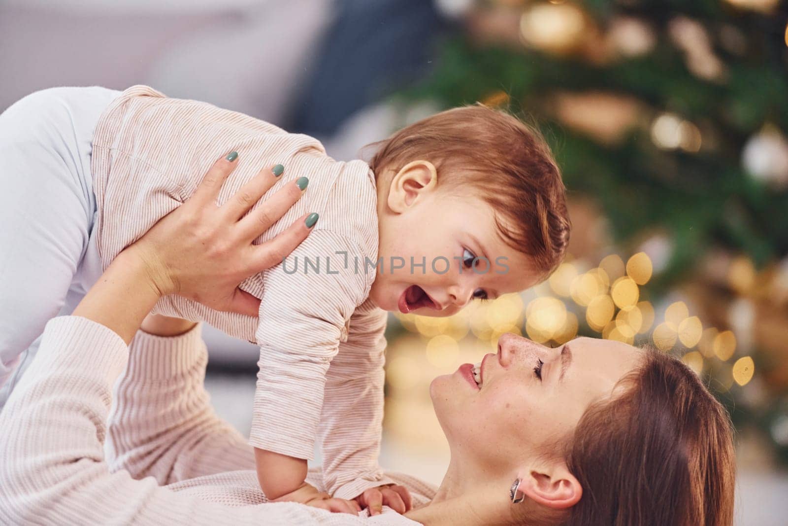 Playing with each other. Mother with her little daughter is indoors at home together.