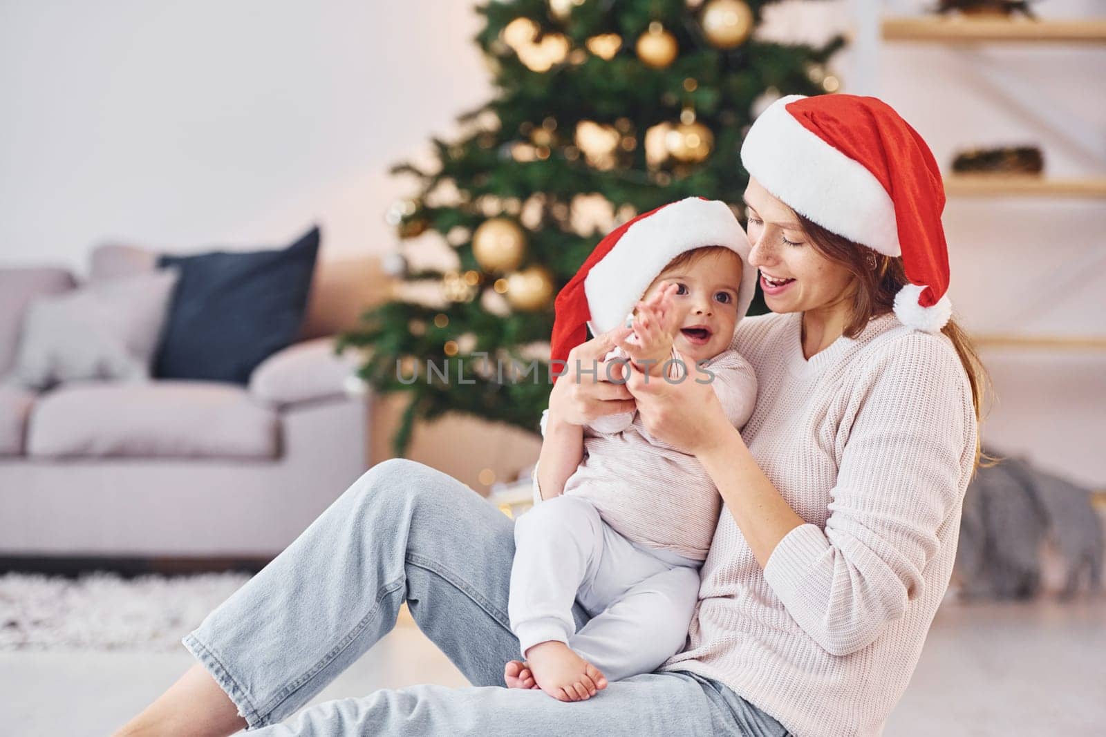 Playing with each other. Mother with her little daughter is indoors at home together.