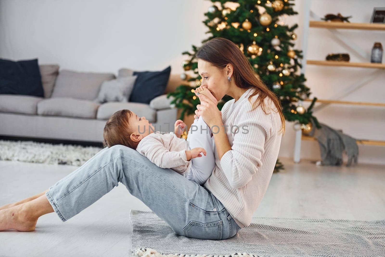 Holiday mood. Mother with her little daughter is indoors at home together.