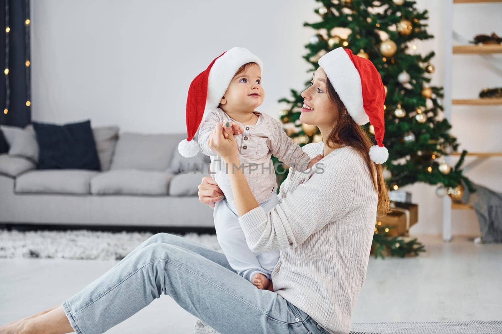 Holiday mood. Mother with her little daughter is indoors at home together.