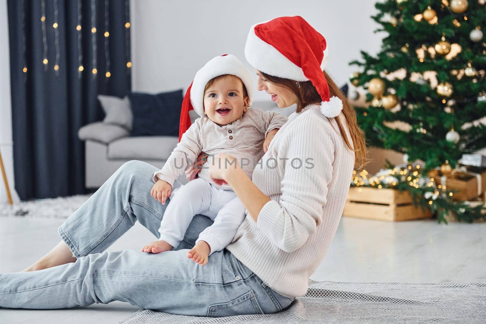 Holiday mood. Mother with her little daughter is indoors at home together.