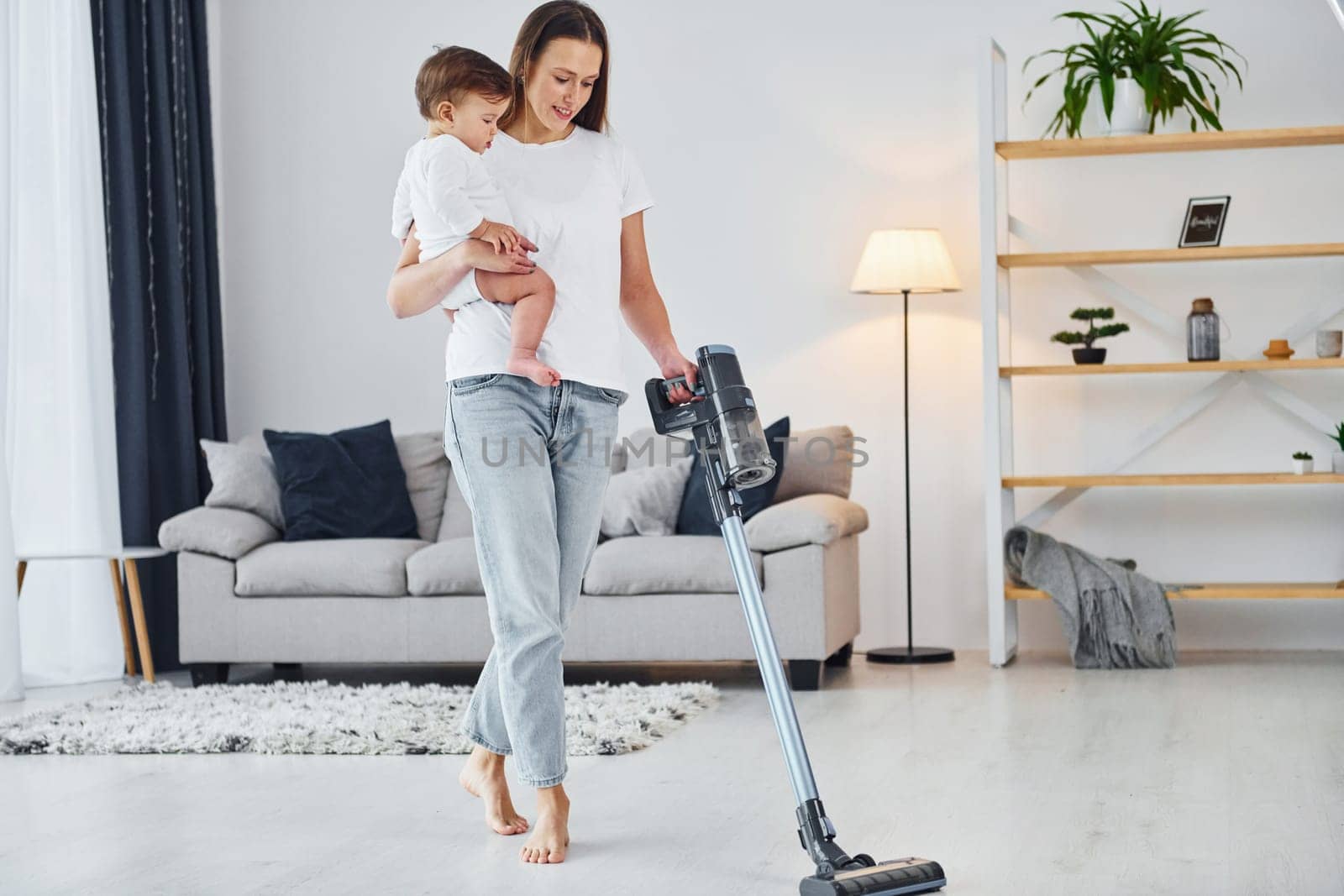 Domestic life. Mother with her little daughter is indoors at home together.