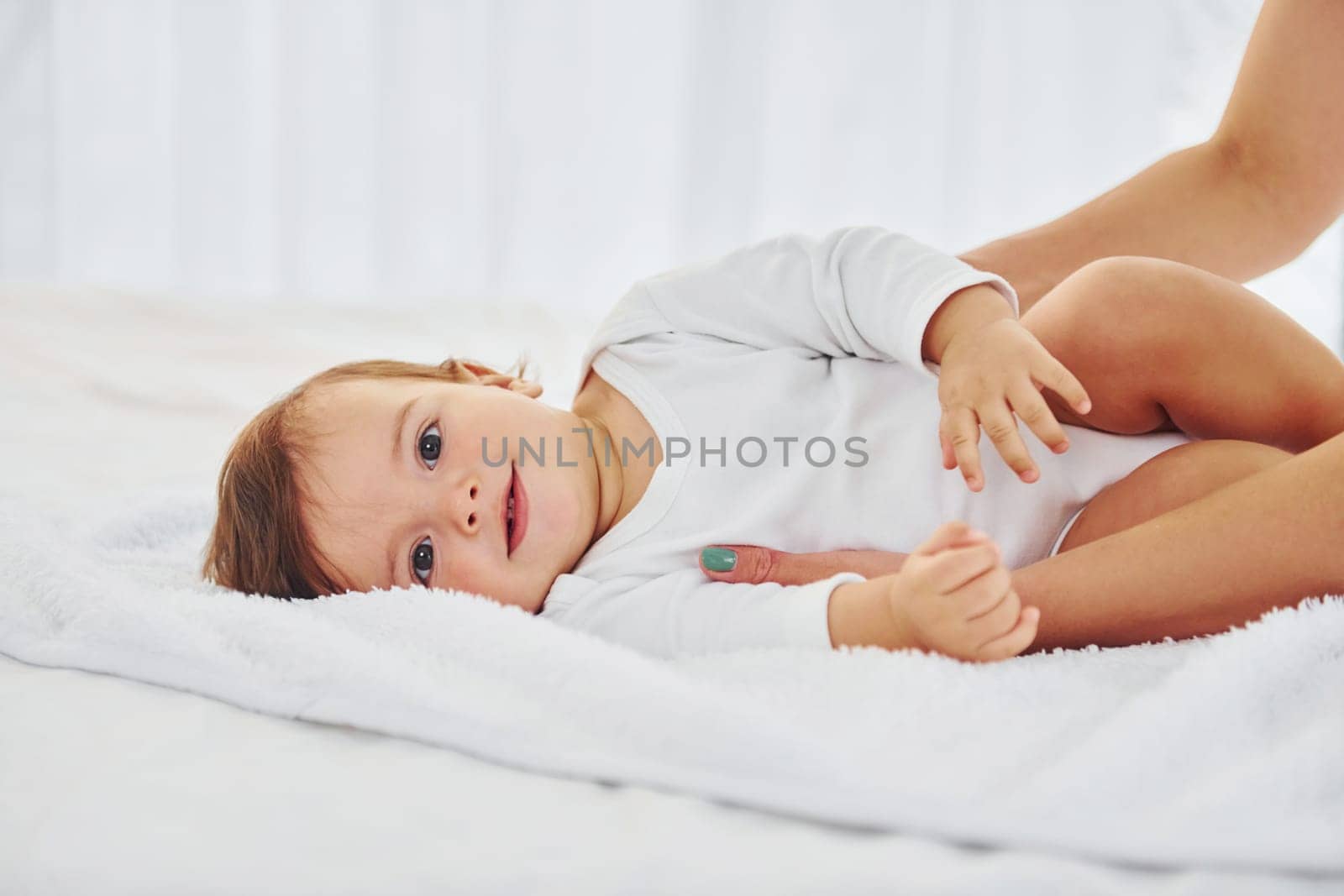Playing around. Mother with her little daughter is indoors at home together.