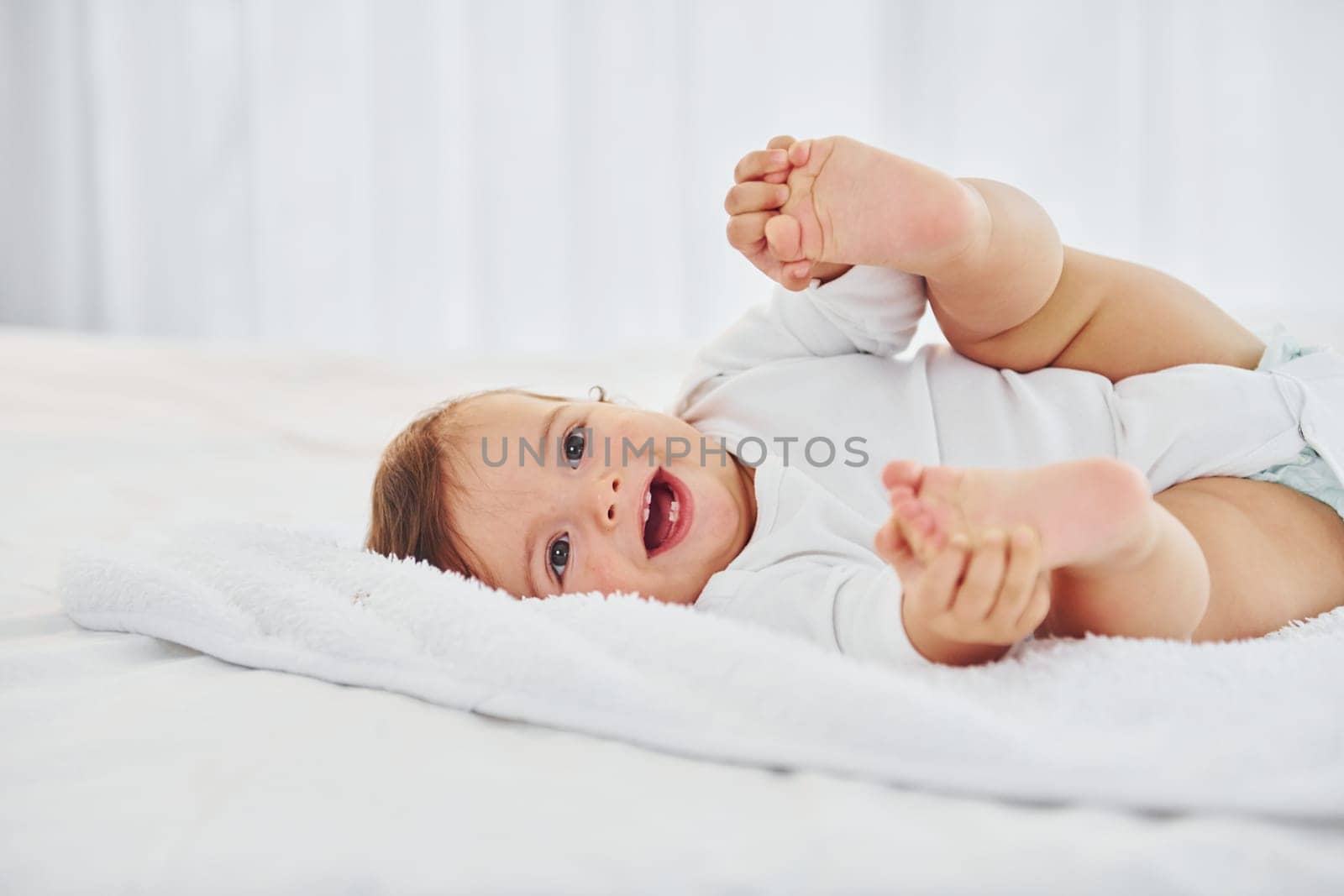 Having fun. Cute little baby is indoors in the domestic room.