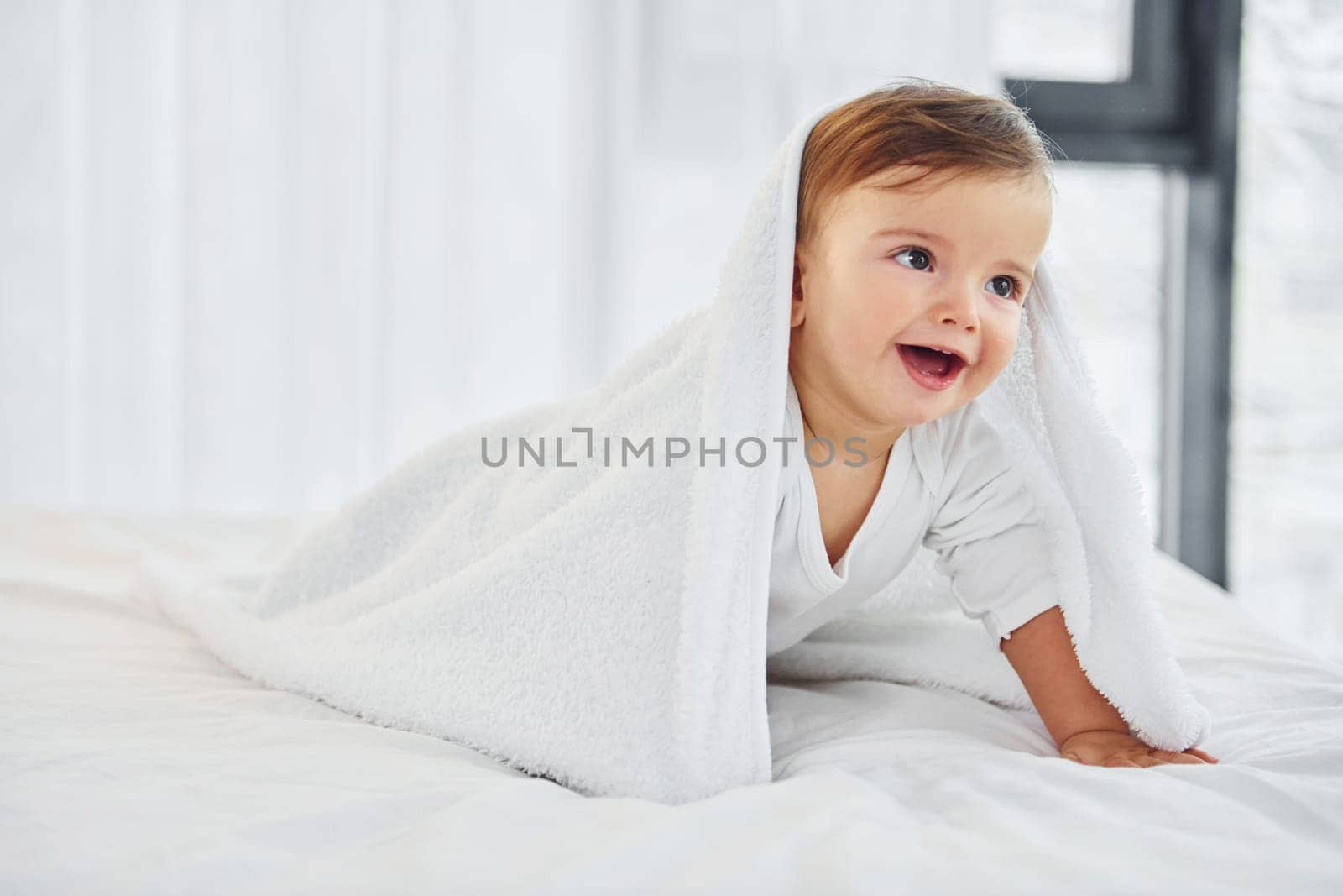 Having fun. Cute little baby is indoors in the domestic room.
