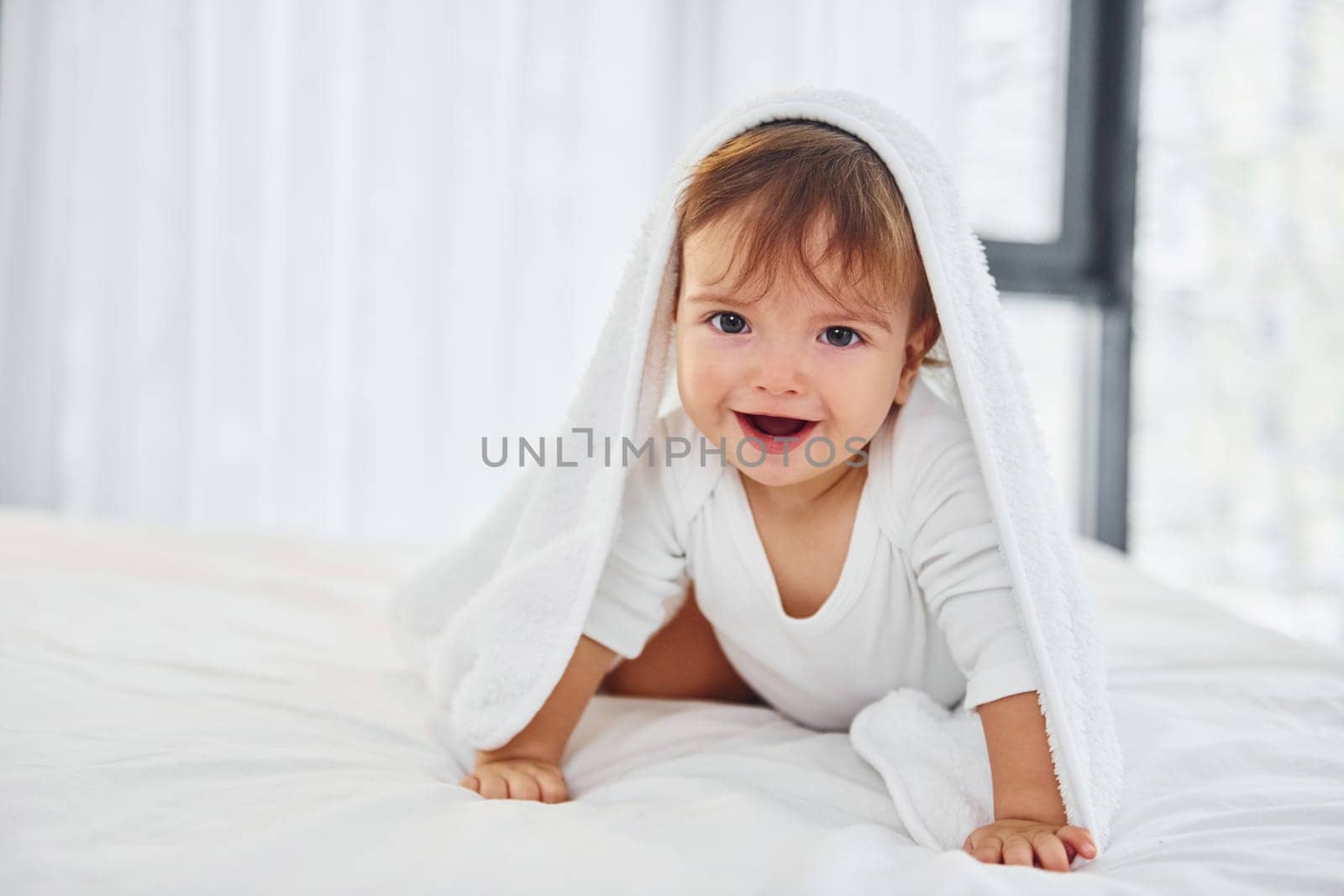 Having fun. Cute little baby is indoors in the domestic room.