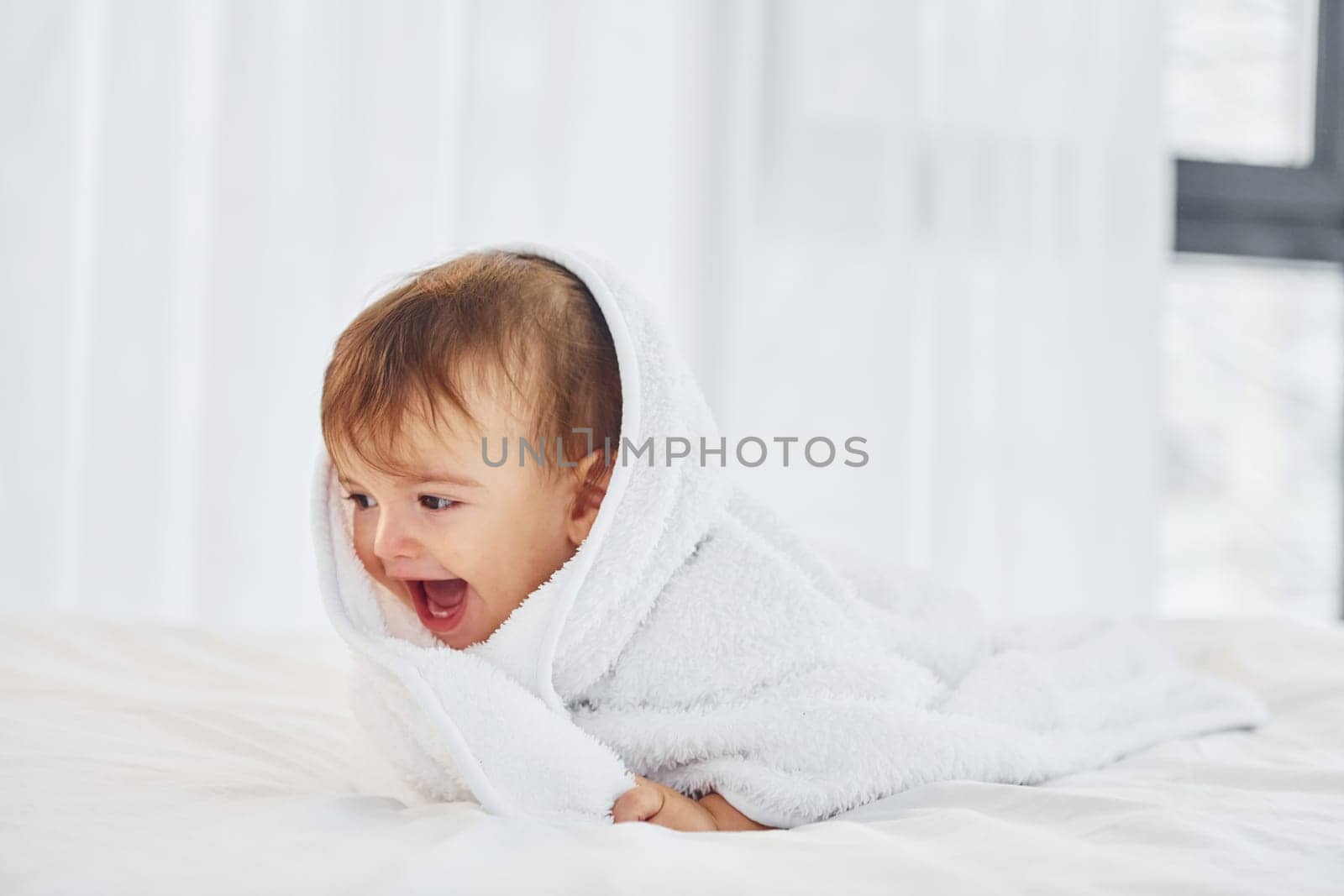 Positive emotions. Cute little baby is indoors in the domestic room.