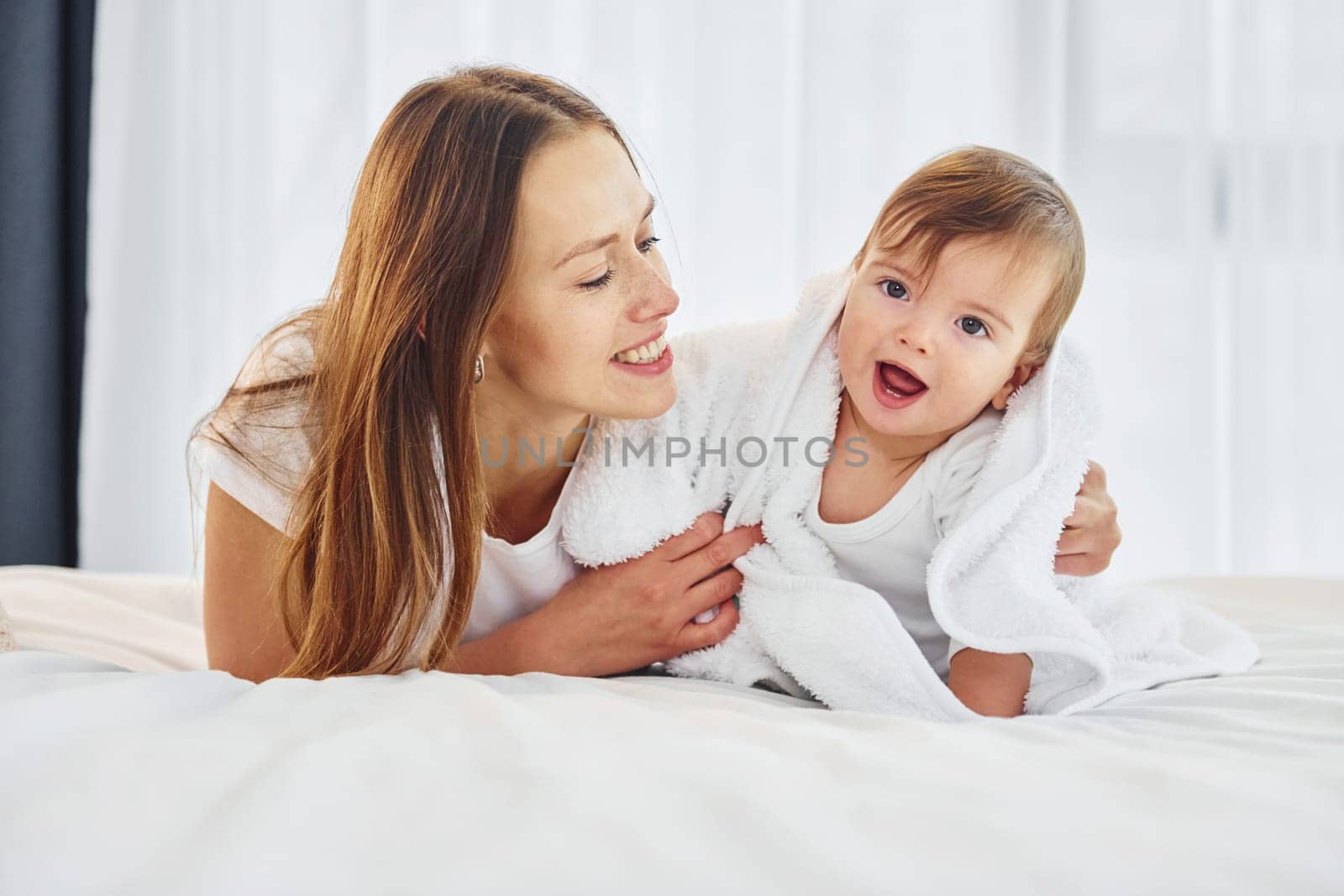 Conception of parenting. Mother with her little daughter is indoors at home together.