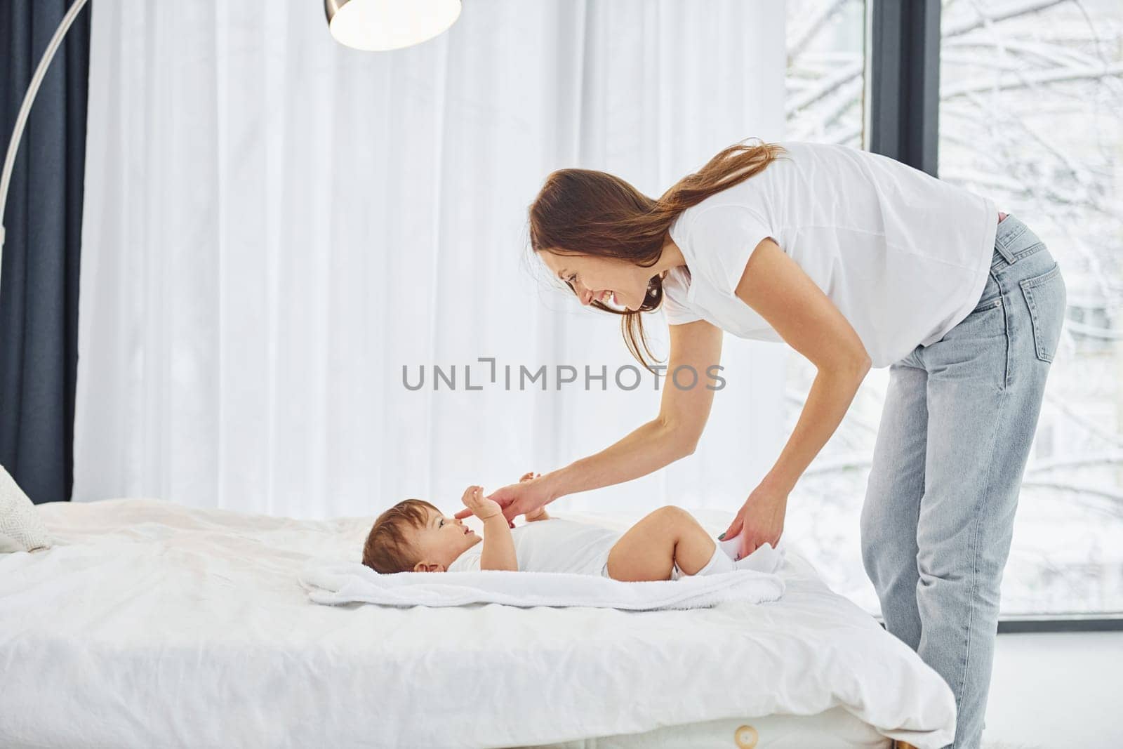 Conception of parenting. Mother with her little daughter is indoors at home together.