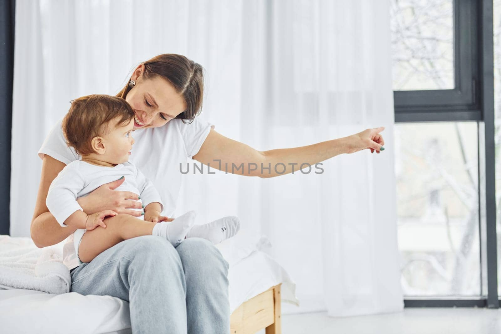 Conception of parenting. Mother with her little daughter is indoors at home together.