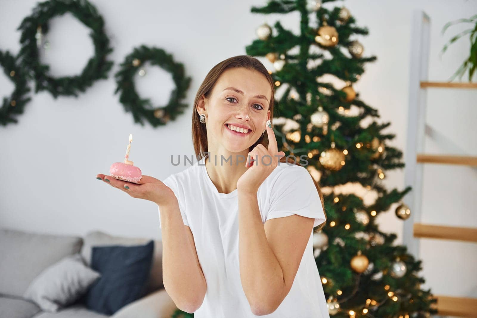 Young woman in casual clothes is indoors in domestic room.