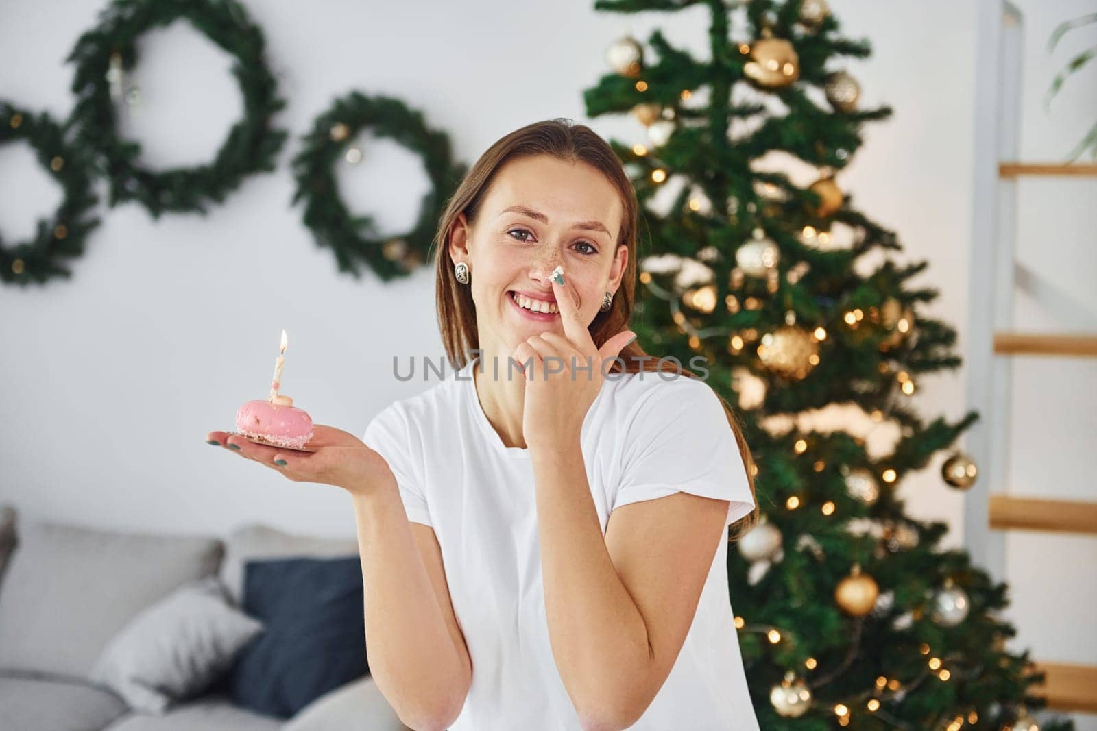 Young woman in casual clothes is indoors in domestic room.