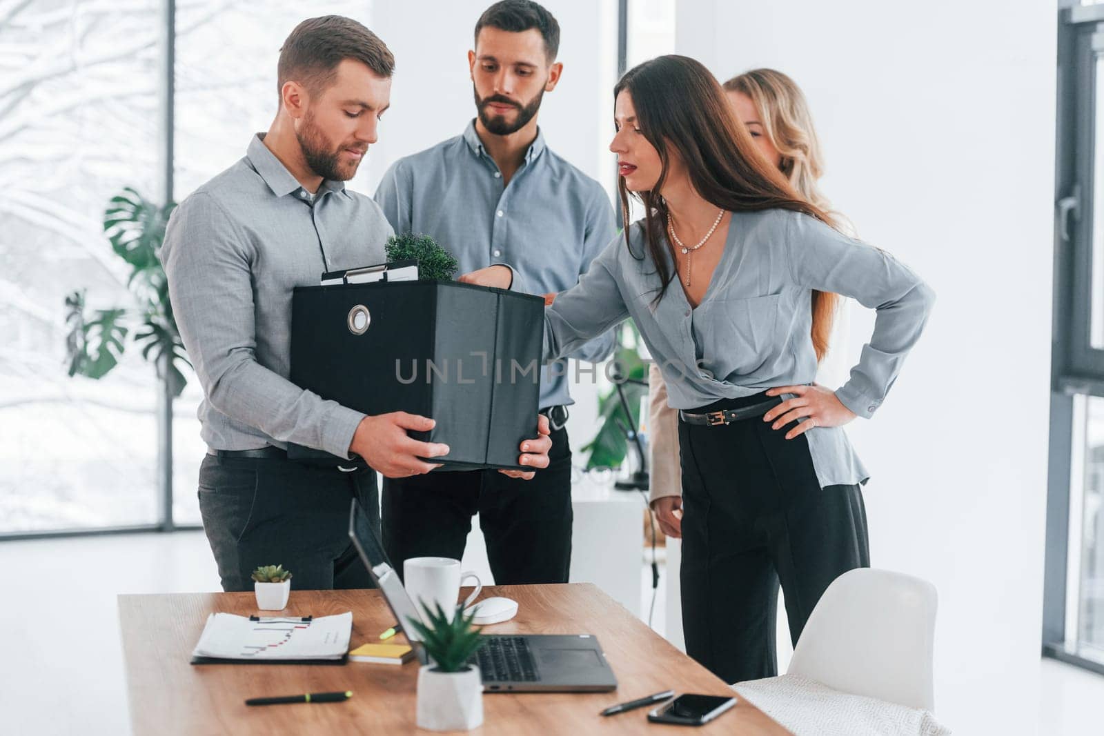 Man holding package. Group of business people that working on the project in the office.