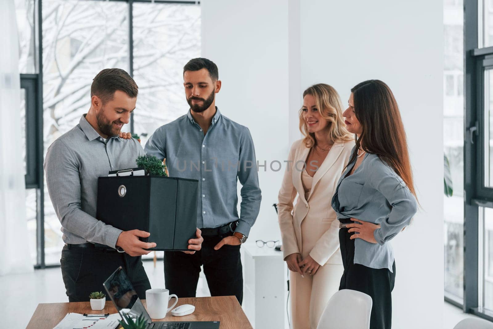 Holding package in hands. Group of business people that working on the project in the office.
