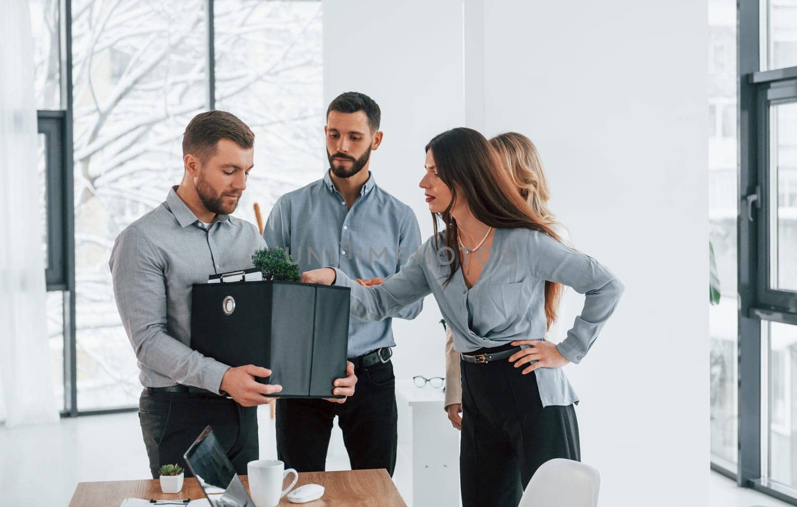 Holding package in hands. Group of business people that working on the project in the office.