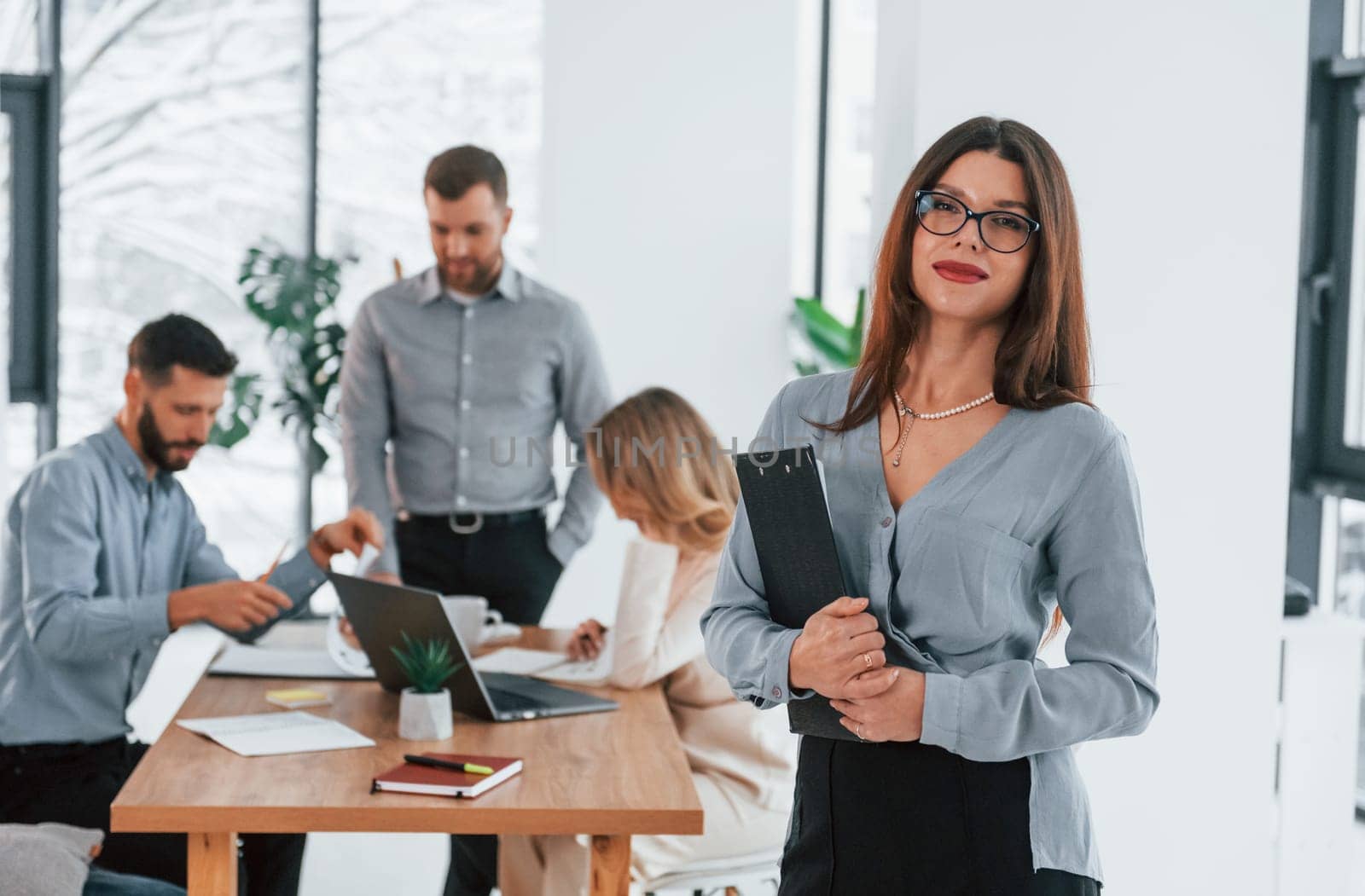 Woman standing in front of her employees. Group of business people that working on the project in the office.