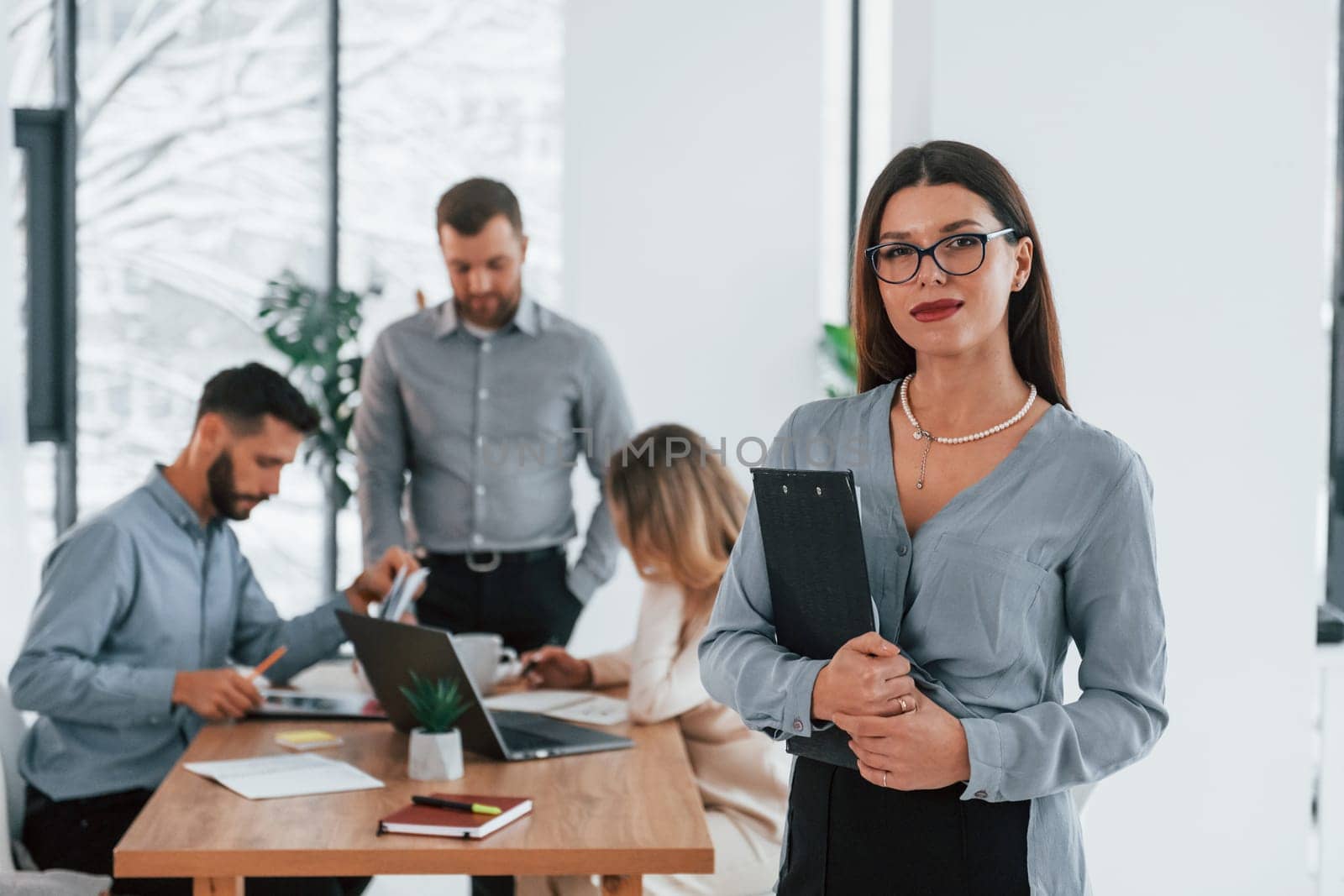 Woman standing in front of her employees. Group of business people that working on the project in the office.