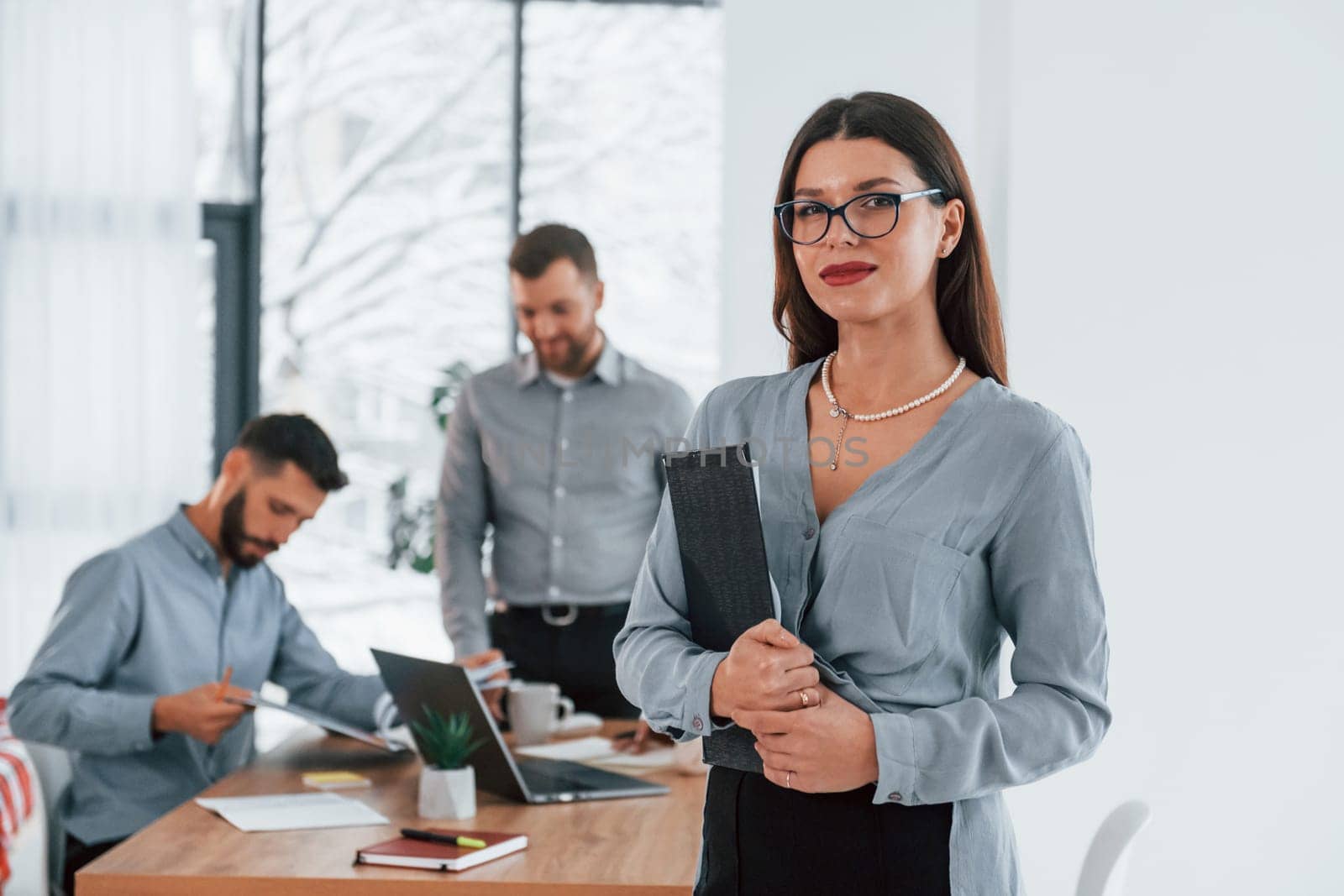 Woman standing in front of her employees. Group of business people that working on the project in the office.
