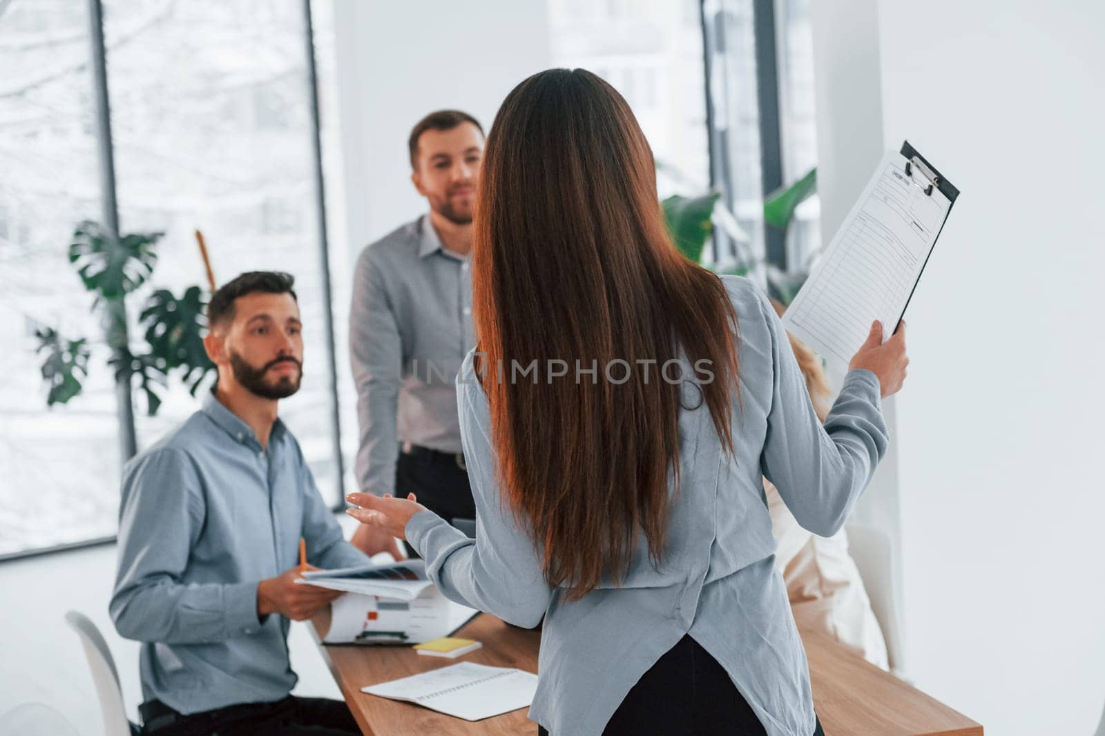 Woman standing in front of her employees. Group of business people that working on the project in the office.