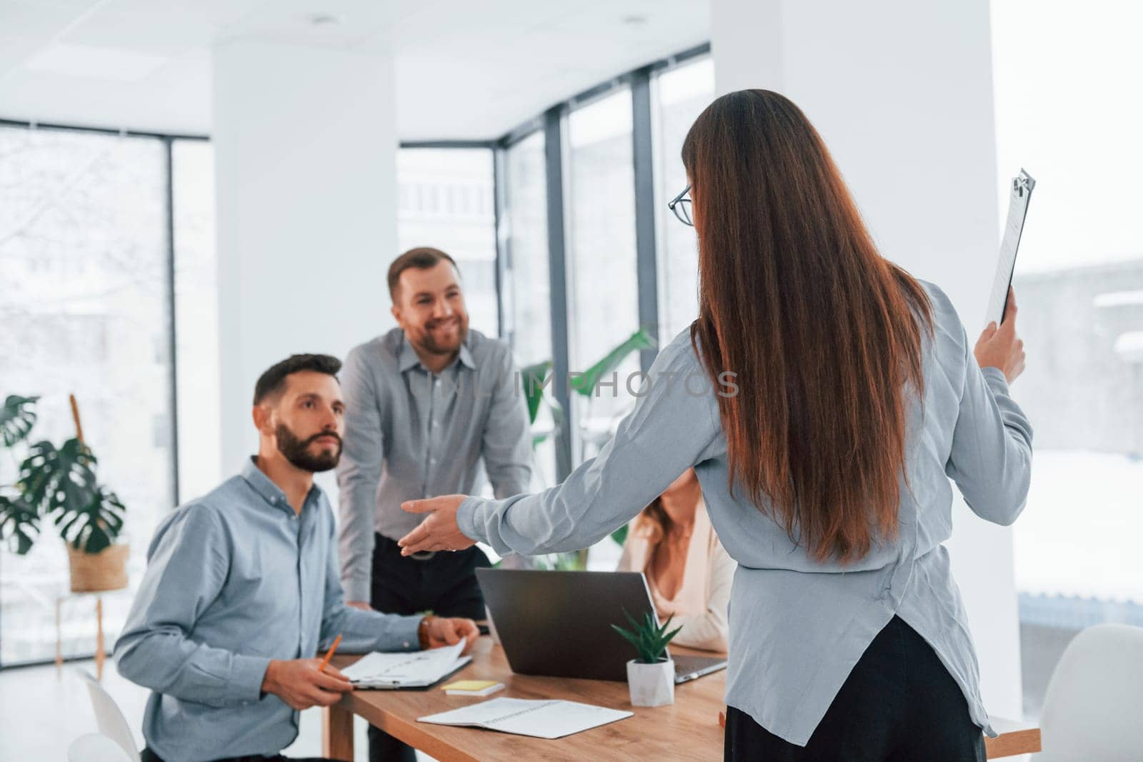 Woman standing in front of her employees. Group of business people that working on the project in the office.